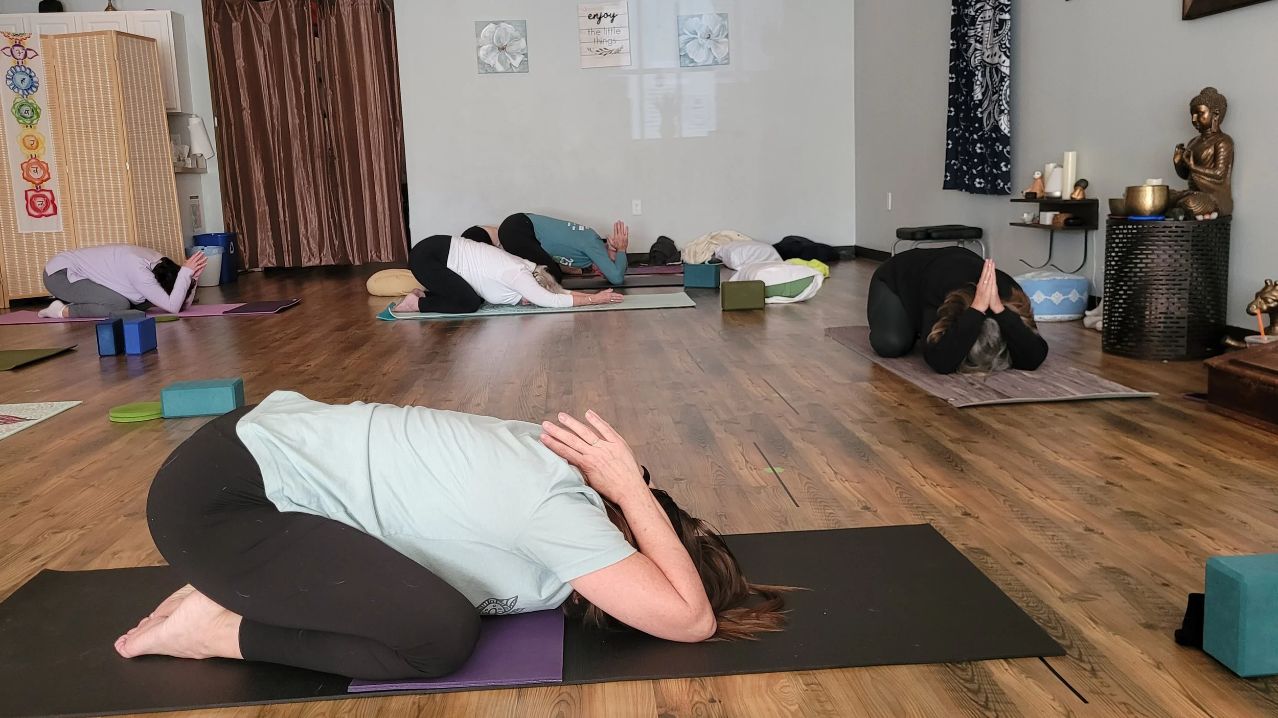 Students resting in child's pose during a yoga class at Emerald Yoga Studio in Pembroke, MA, near Hanover