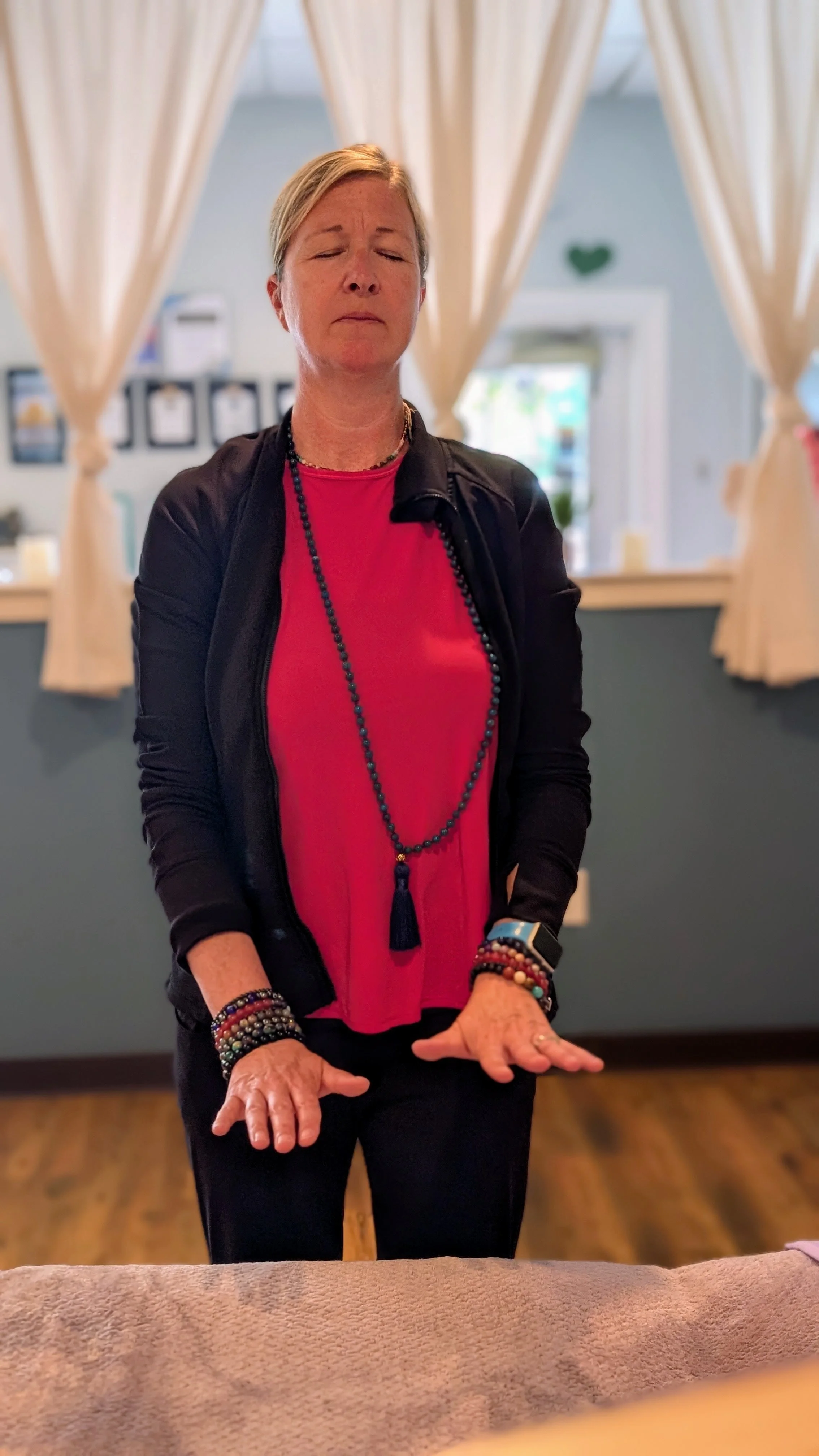 Reiki Healing Sessions at Emerald Yoga Studio in Pembroke MA Person Holding Hands Over Table