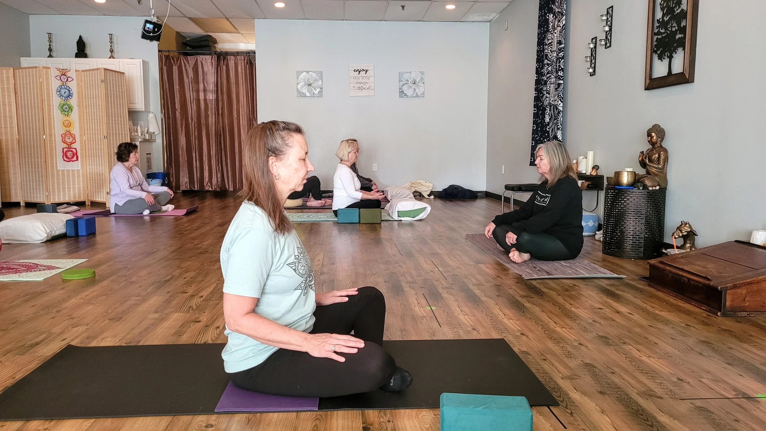 Students seated on yoga mats during a gentle class at Emerald Yoga Studio in Pembroke, MA, near Norwell