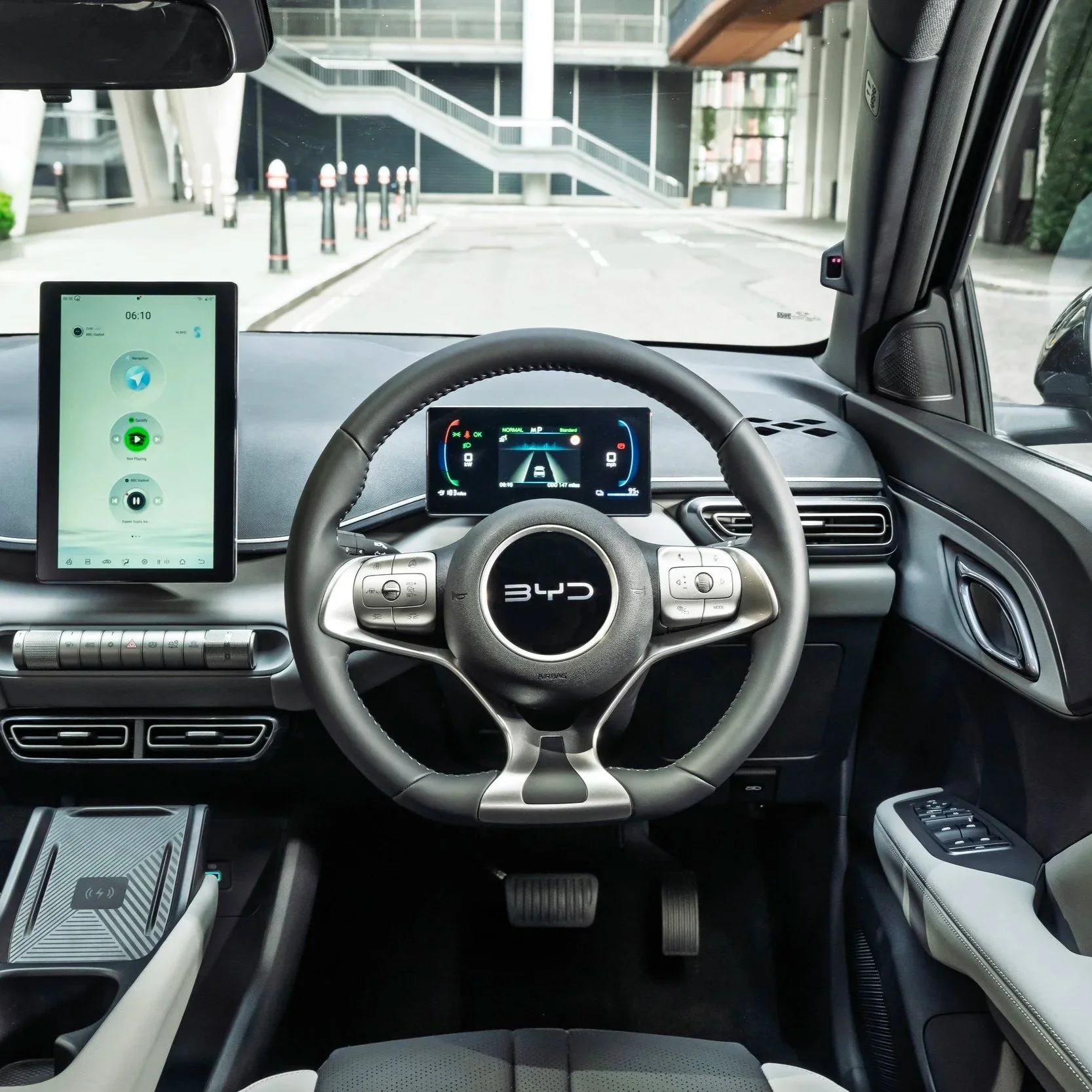 Interior view of a BYD electric vehicle's dashboard and steering wheel, with digital displays and controls visible.