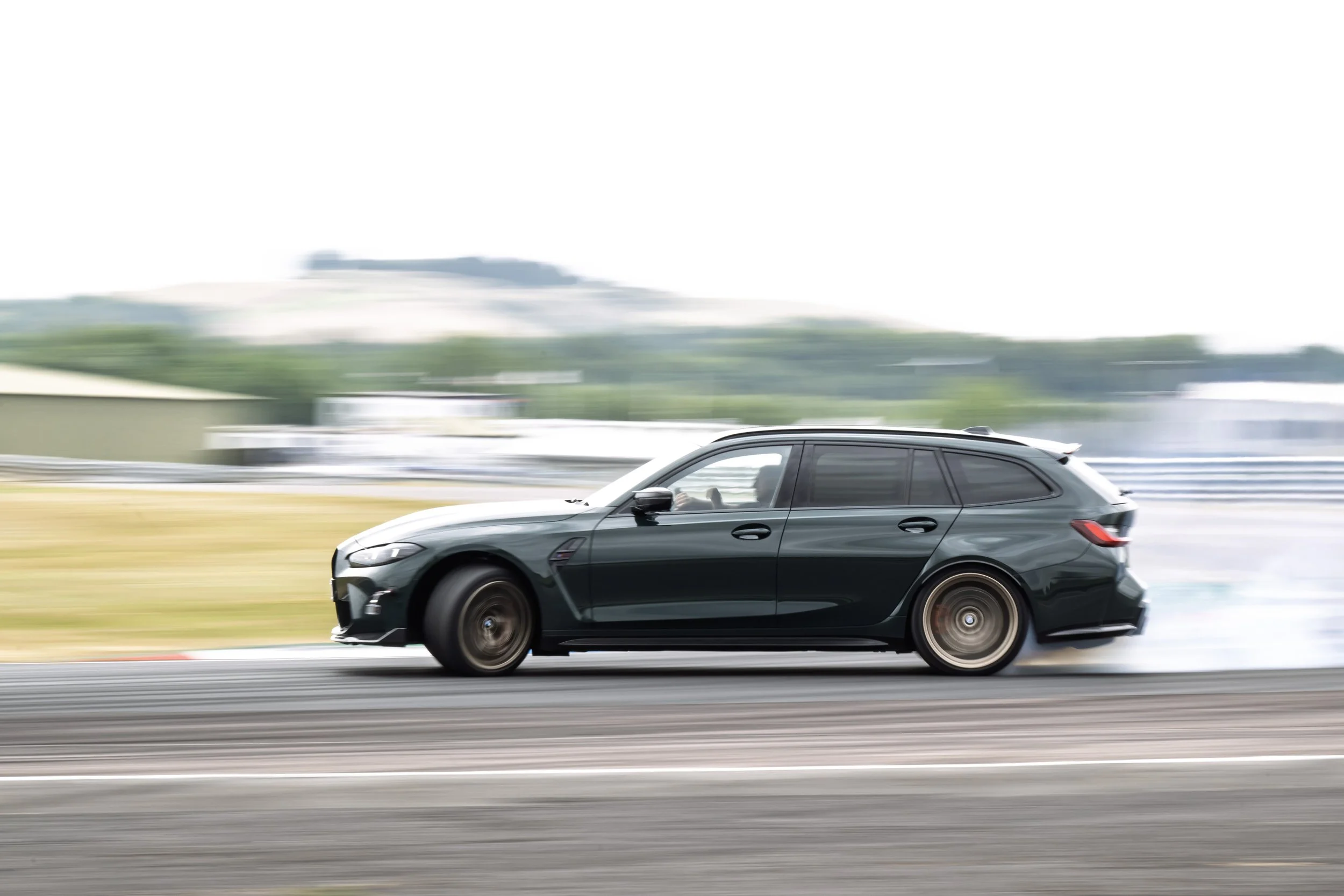 A gray sports car racing on a track with motion blur in the background, creating a sense of speed.