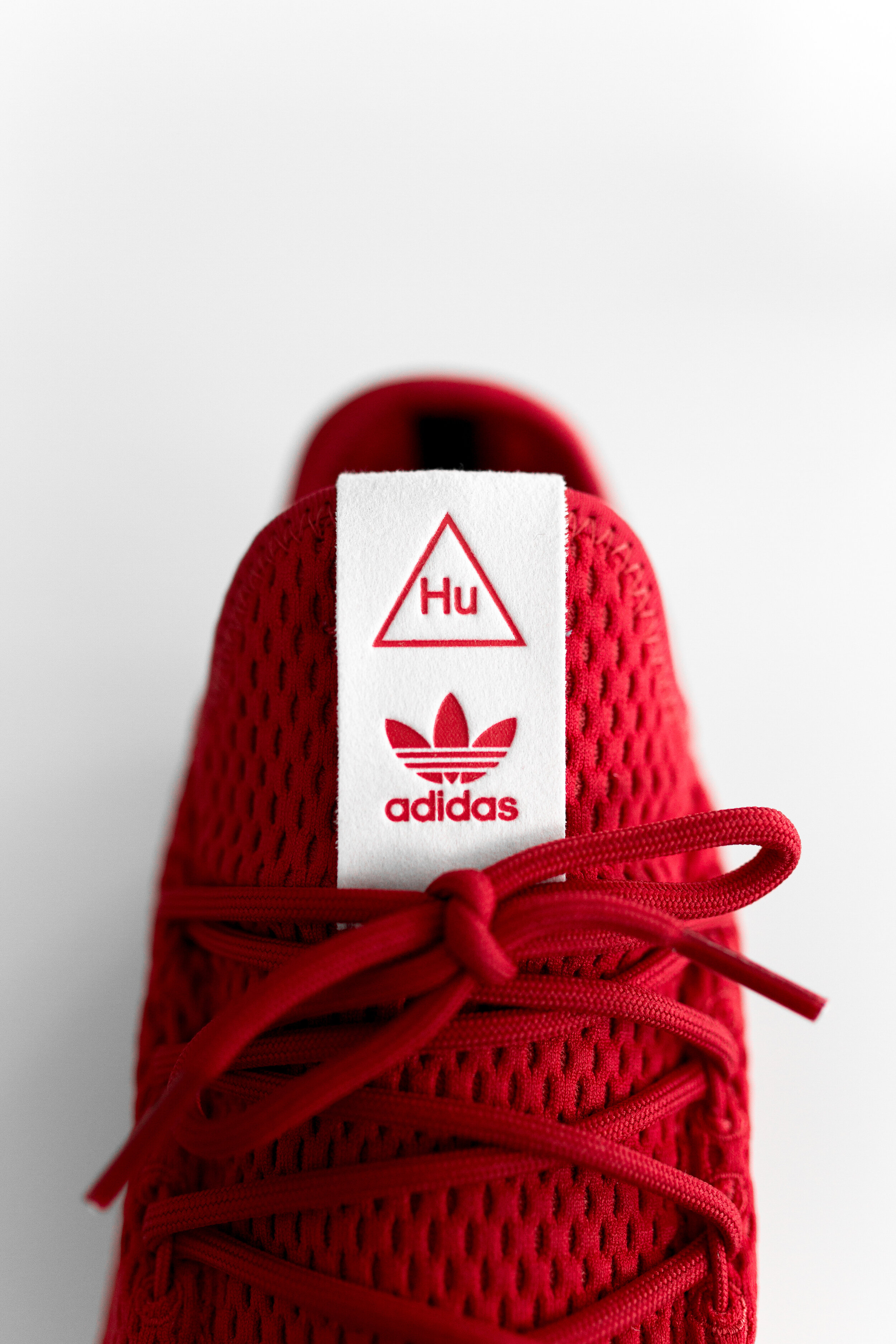Close-up of a red Adidas sneaker with Hu branding on the tongue.