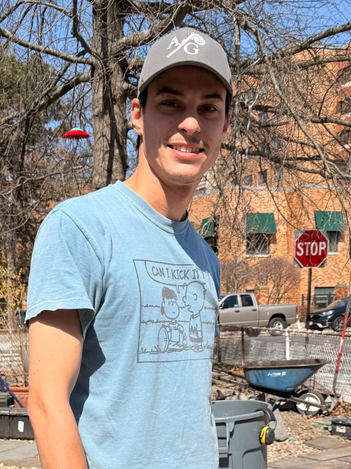 A young man with a hat standing with equipment at worksite