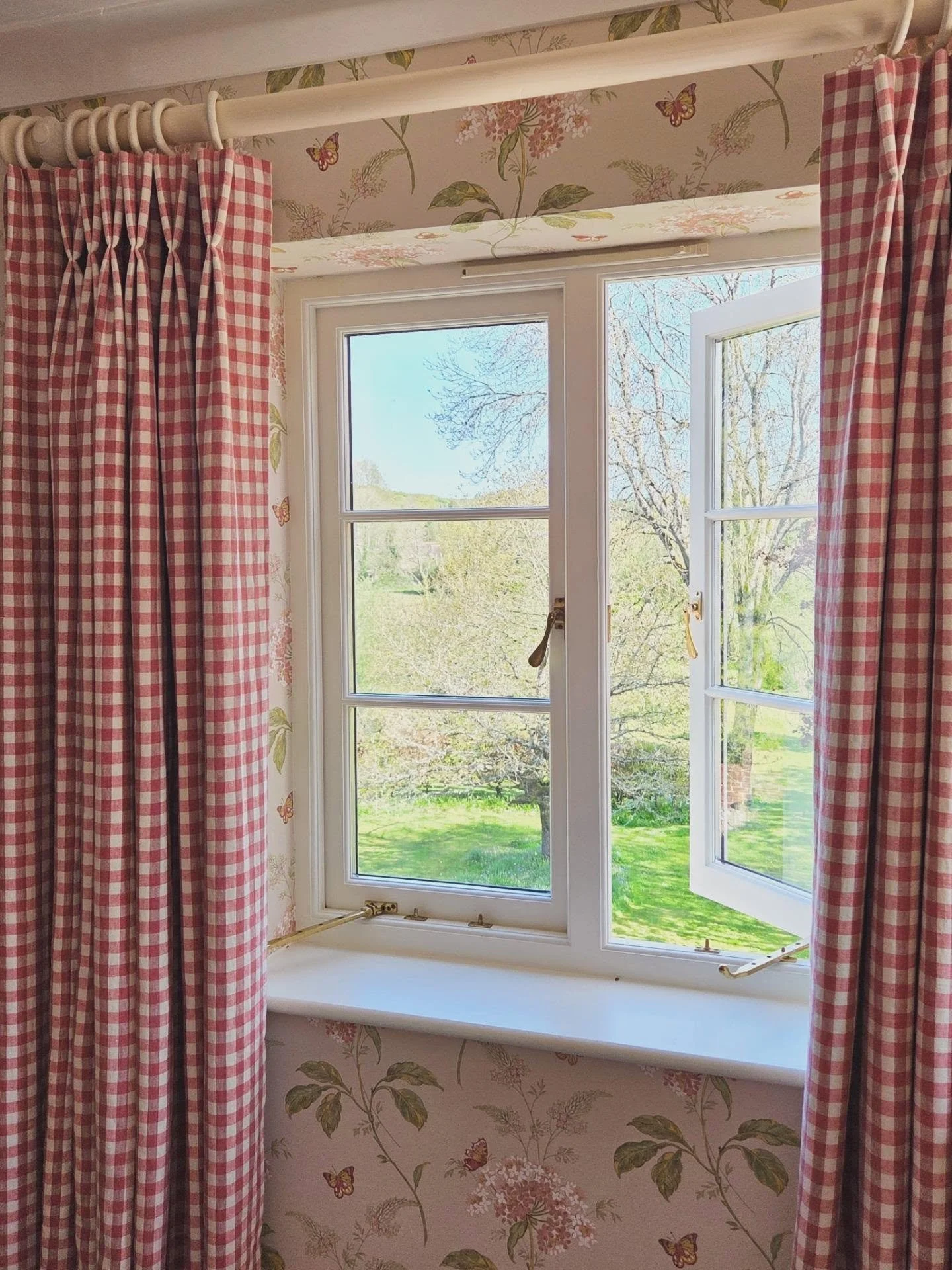 Hydrangeas, butterflies and checks for this charming bedroom.  @colefaxandfowler Messina wallpaper such a fabulous backdrop and perfectly complemented with a classic check for the curtains and blinds.

#countryfurnishings #handmadecurtainsandblinds #