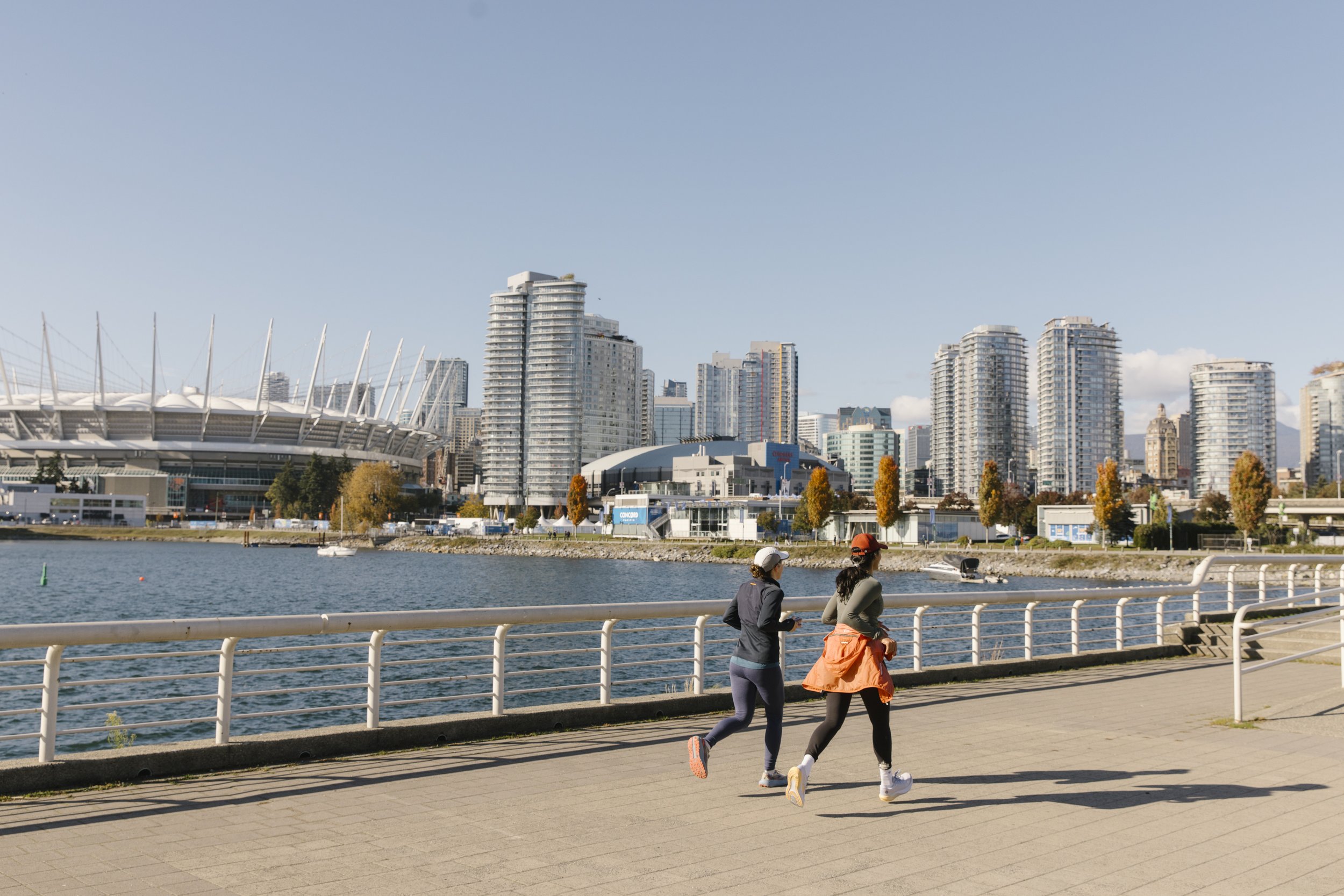 Runners on the seawall in vancouver with BC Place in the background