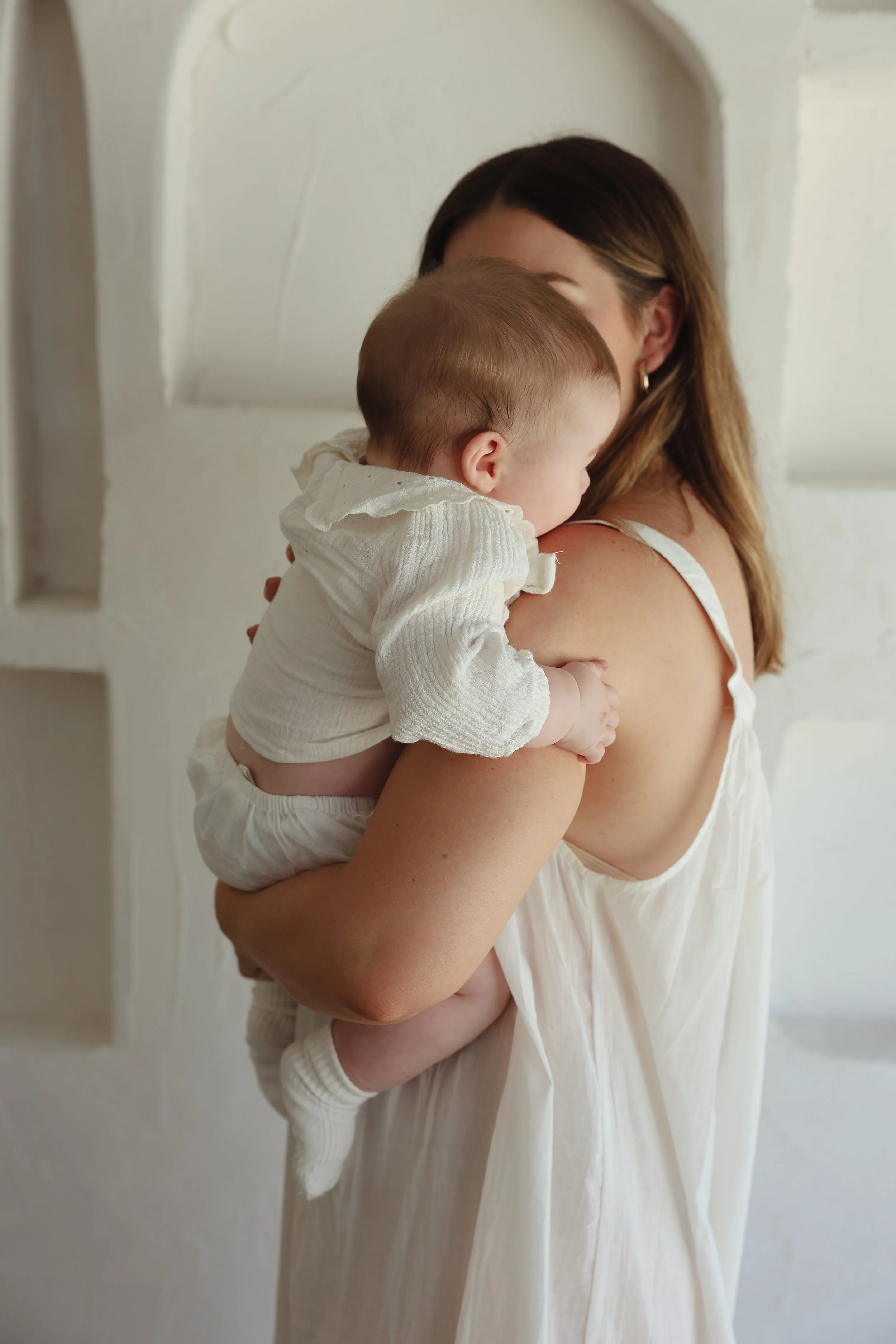A woman holding a sleeping baby on her shoulder
