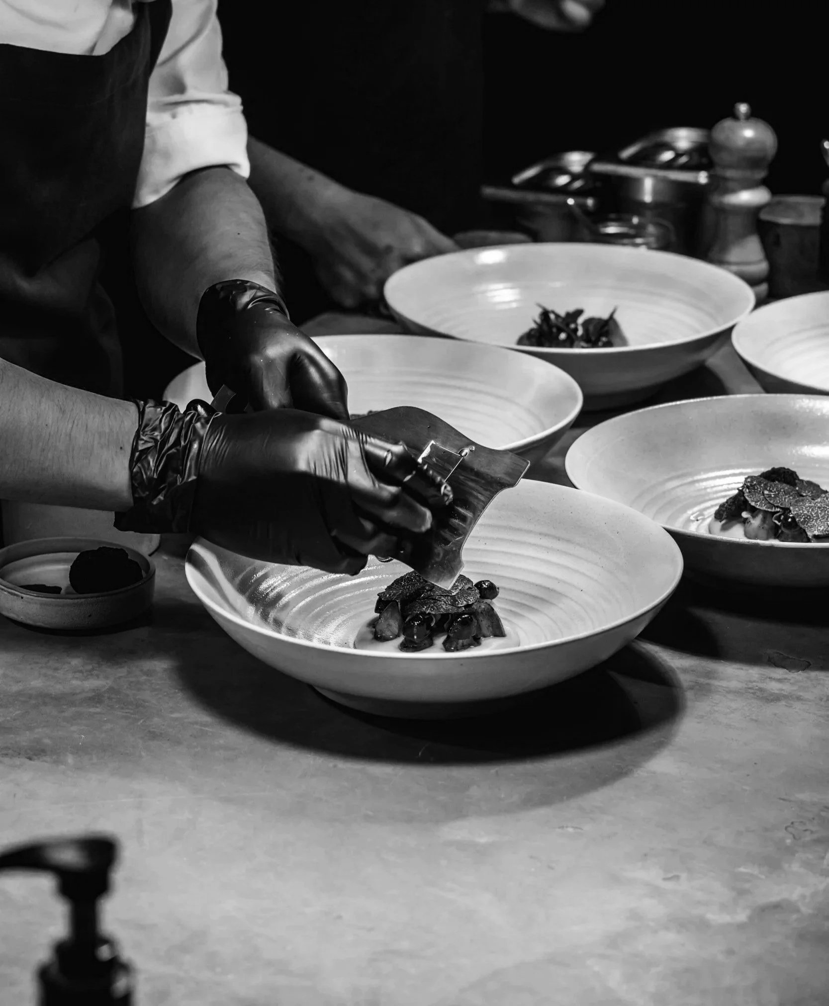 Chef plating a composed dish during a private dining service