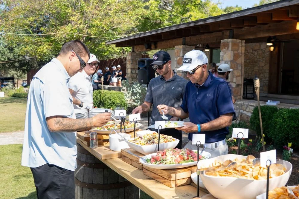 Men serving themselves from a lunch buffet outside