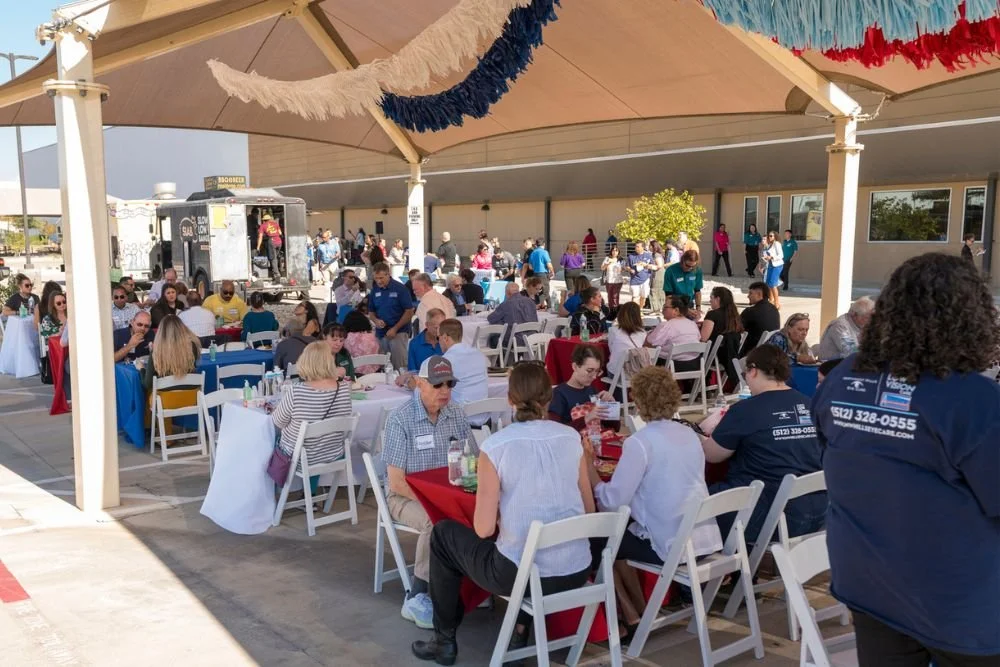 Guests eating lunch under decorated pavilion at outdoor group event