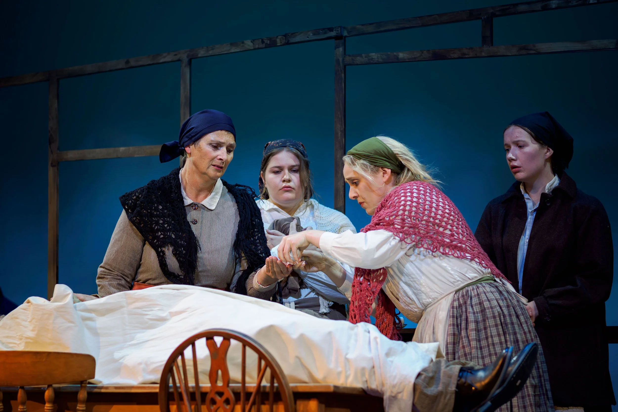 Louisa Pilkington (Maurya), Erin Connelly-Whyte (Cathleen), Matilda Wickbom (Nora), and Anna Engelbrecht (Keening Woman) sing over the body of Barley (Nigel Withington)
