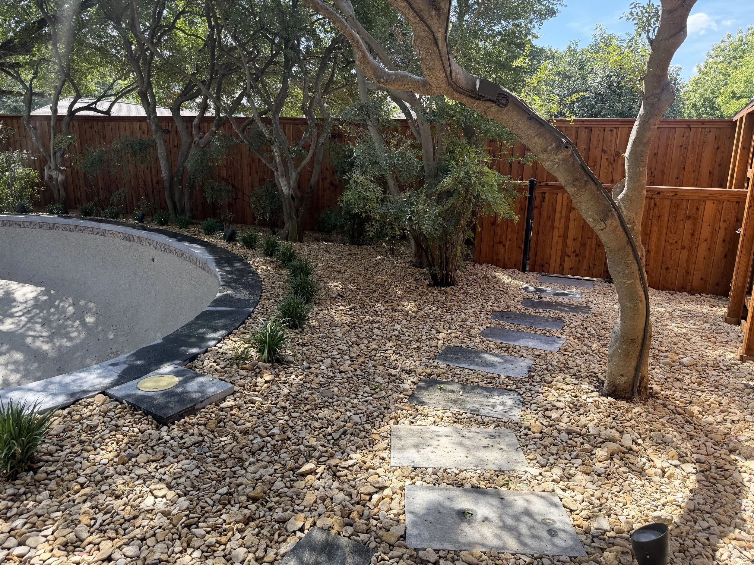 Gravel pathway and stone edging beside a green lawn
