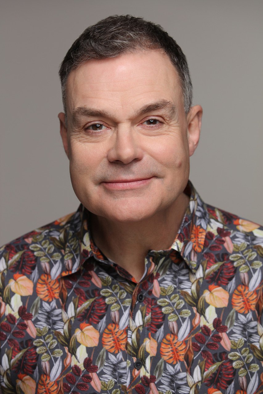 Headshot of Neil Mullarkey in colourful shirt