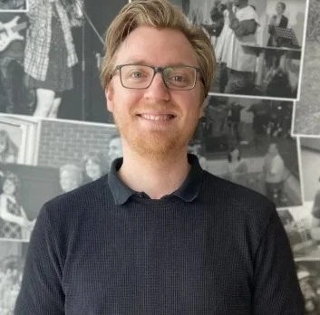 Image of man with blue jumper wearing glasses