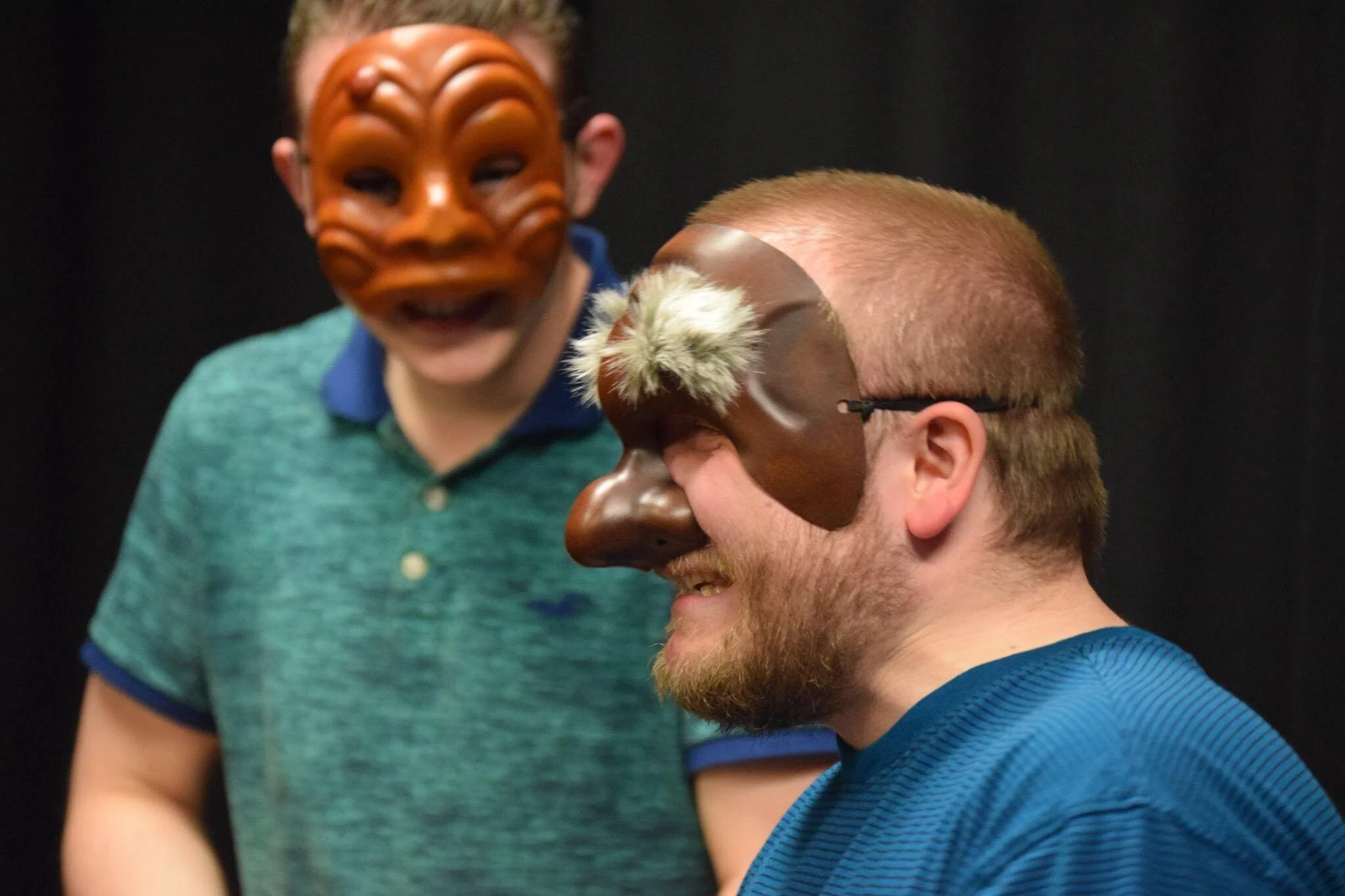 two actors in masks in close up