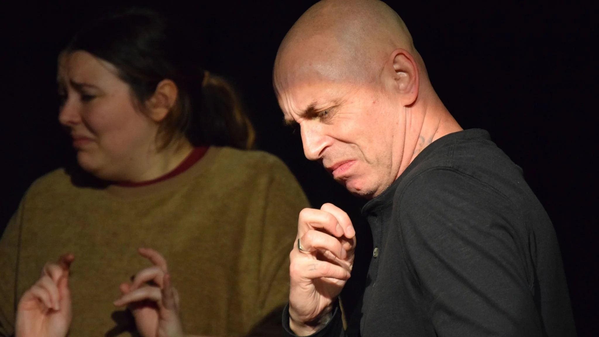 two actors with faces and hands showing expressions of disgust and fear