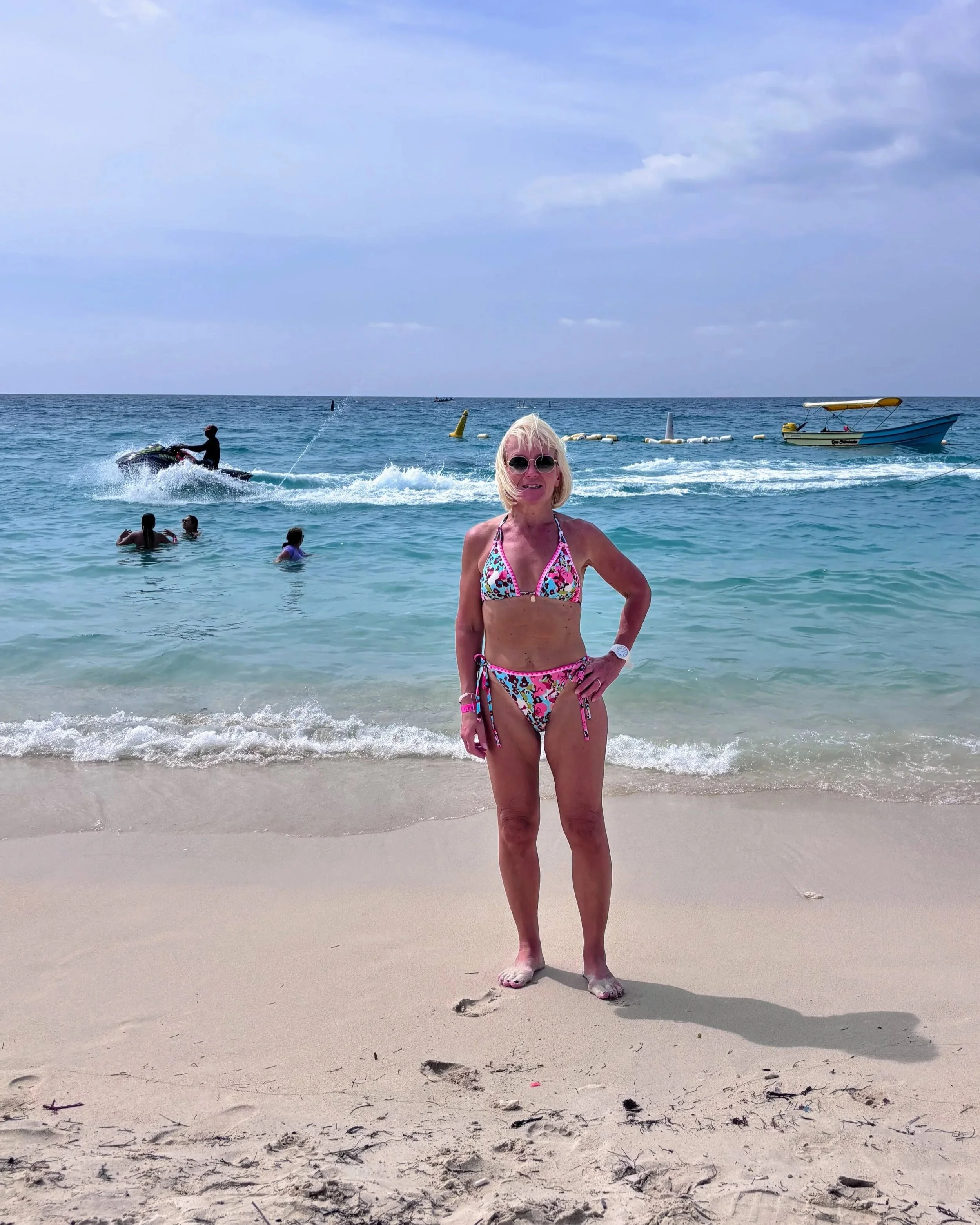 Anita standing at the waterfront on a white sand beach in Playa Blanca in Cartagena Colombia