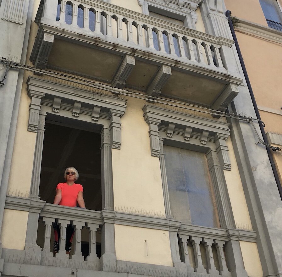 Anita guarda dalla finestra senza infissi primo giorno di ristrutturazione