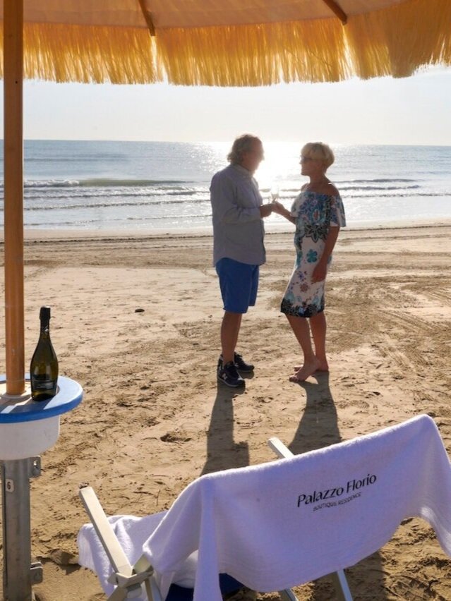 Anita and Umberto toasting prosecco on sunny beach in Vasto Marina