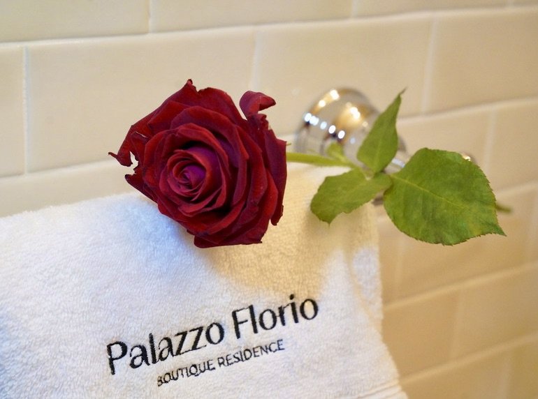 Dettaglio in bagno con rosa rossa e asciugamano ricamato