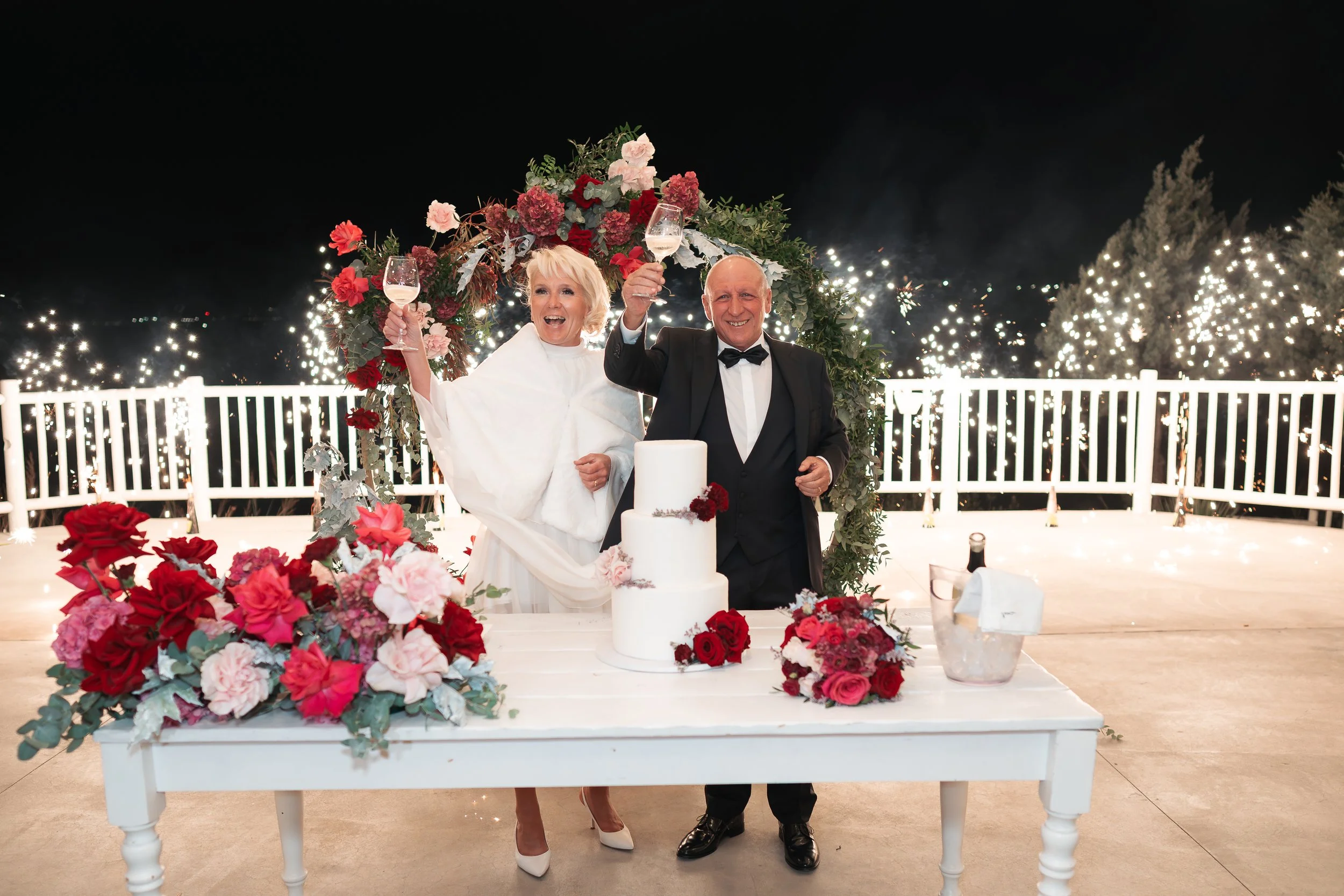 anita and umberto raising a toast at their wedding right after cutting the cake