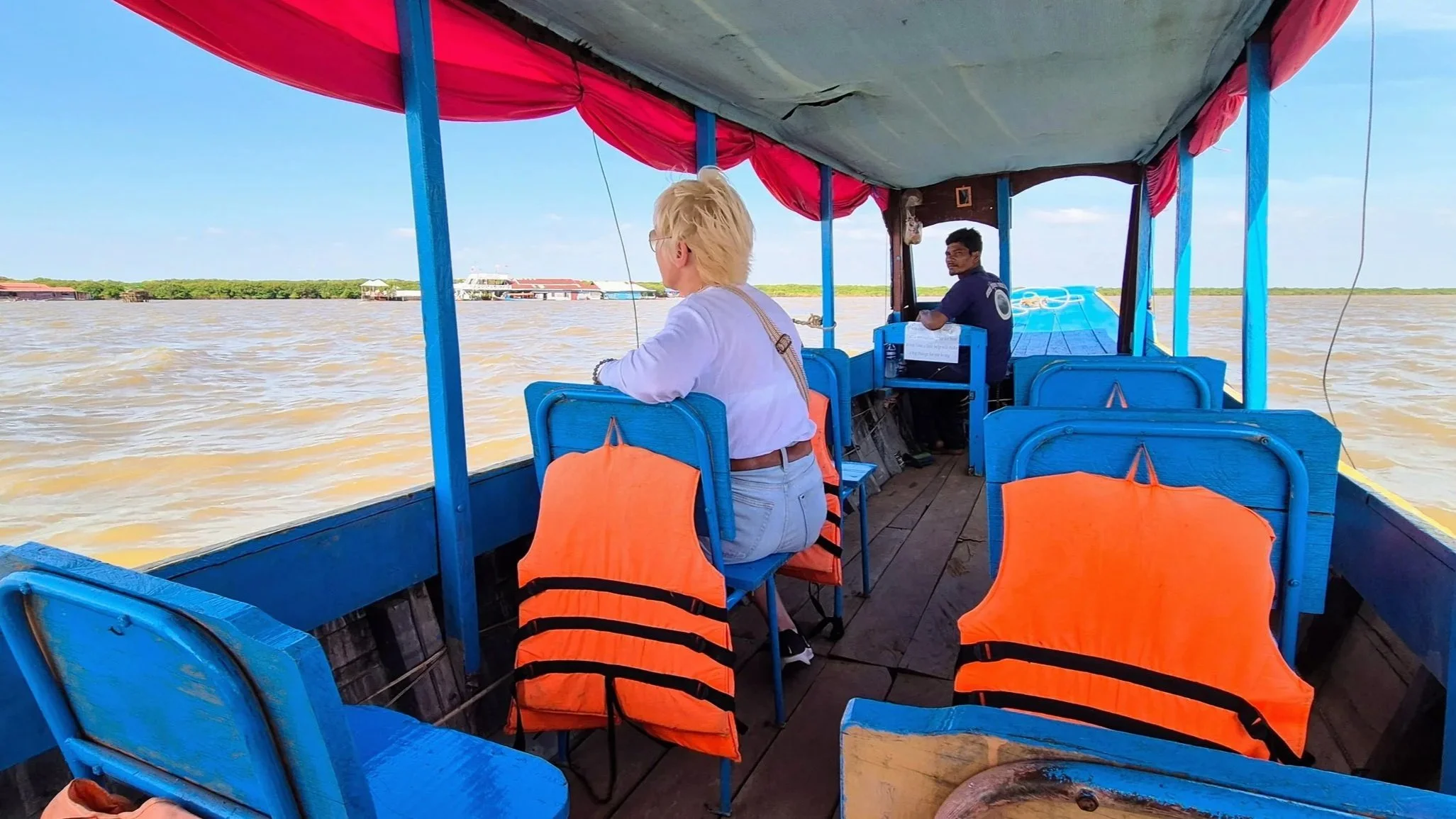 Anita in a blue covered boat on Tonlé Sap Lake in Cambodia