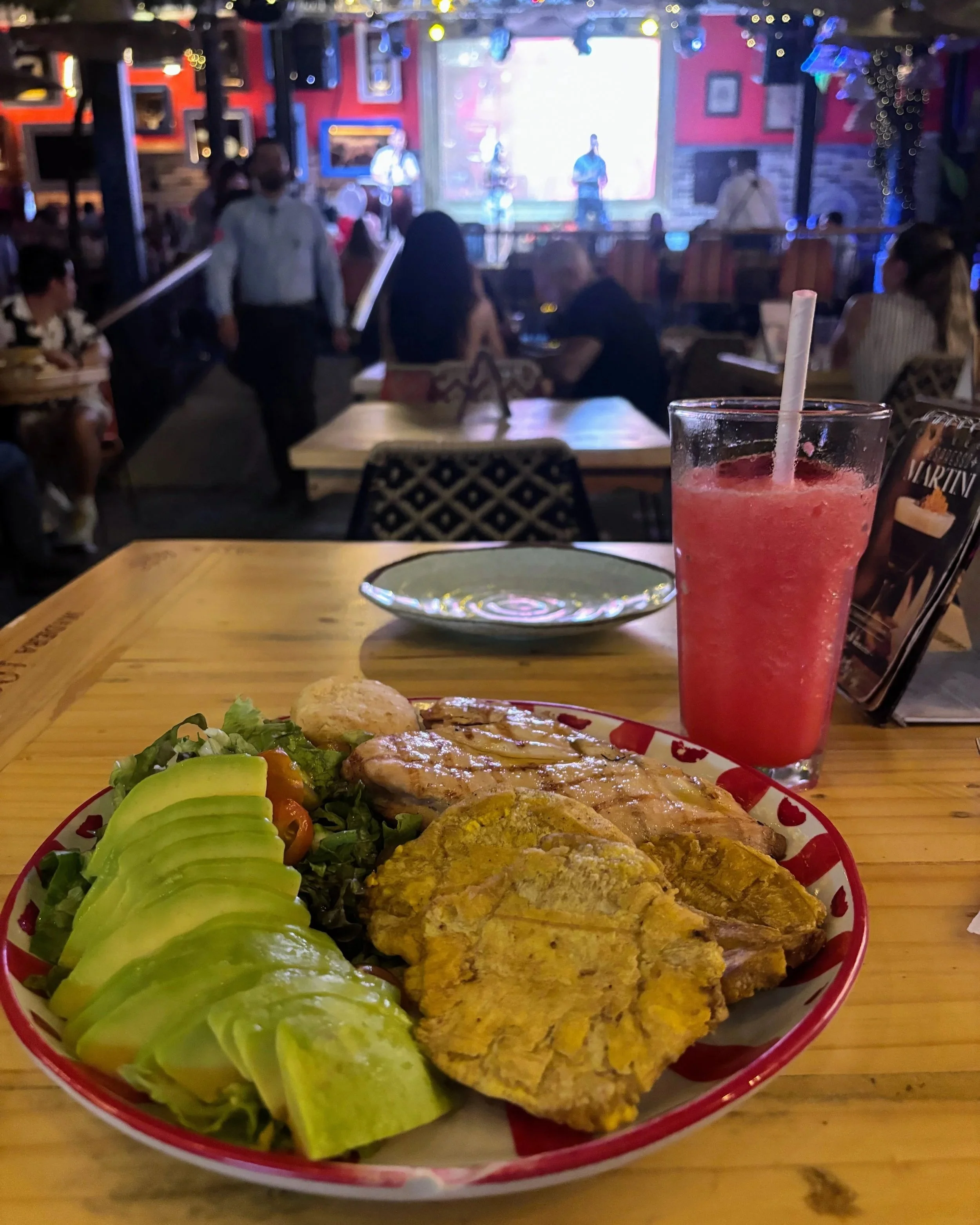 At dinner at La Matriarcha in Medellin, with a dish of chicken, avocado, salad and patacones, and a salsa band playing live in the background