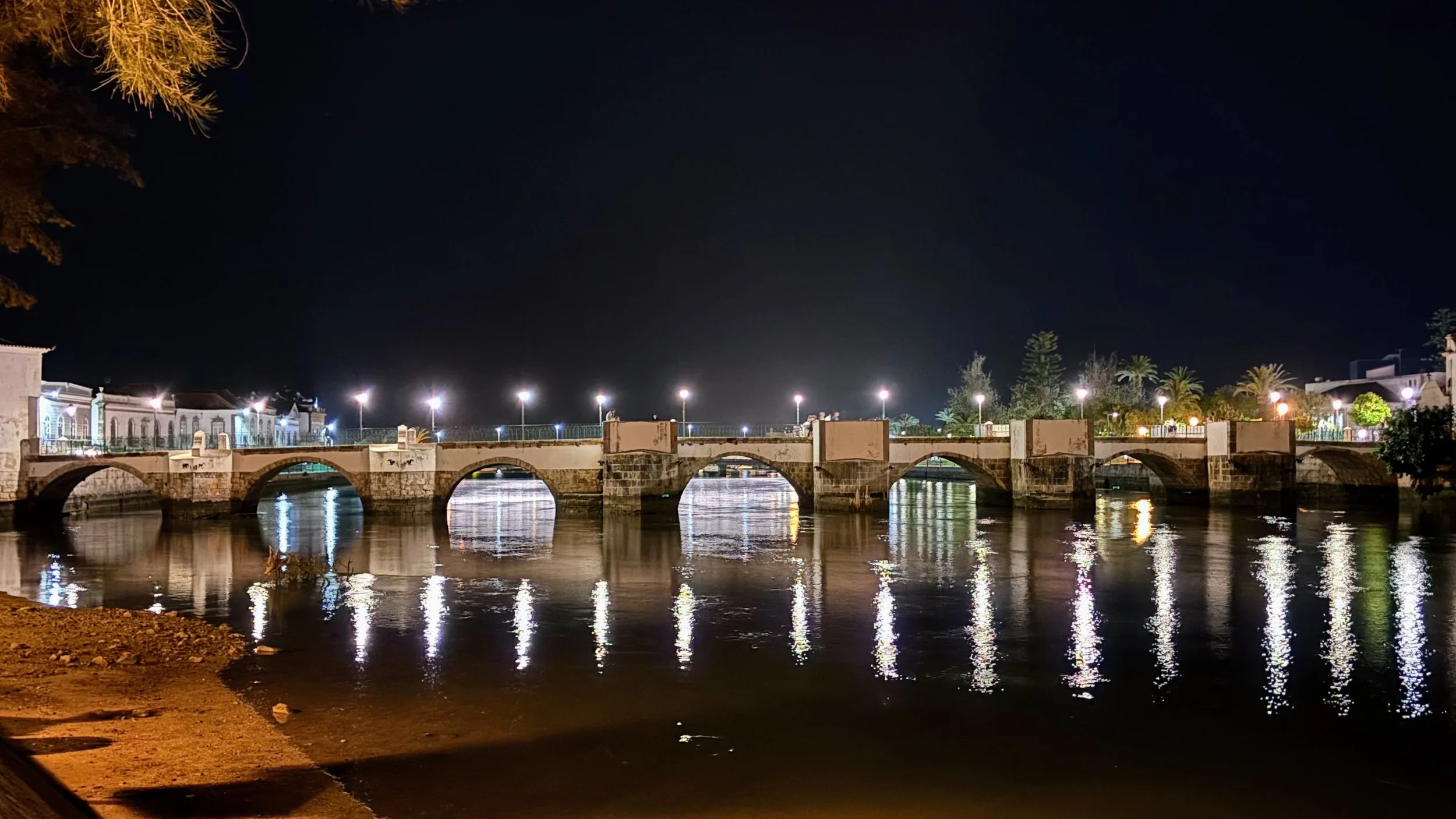Tavira illuminated old bridge across the river at night