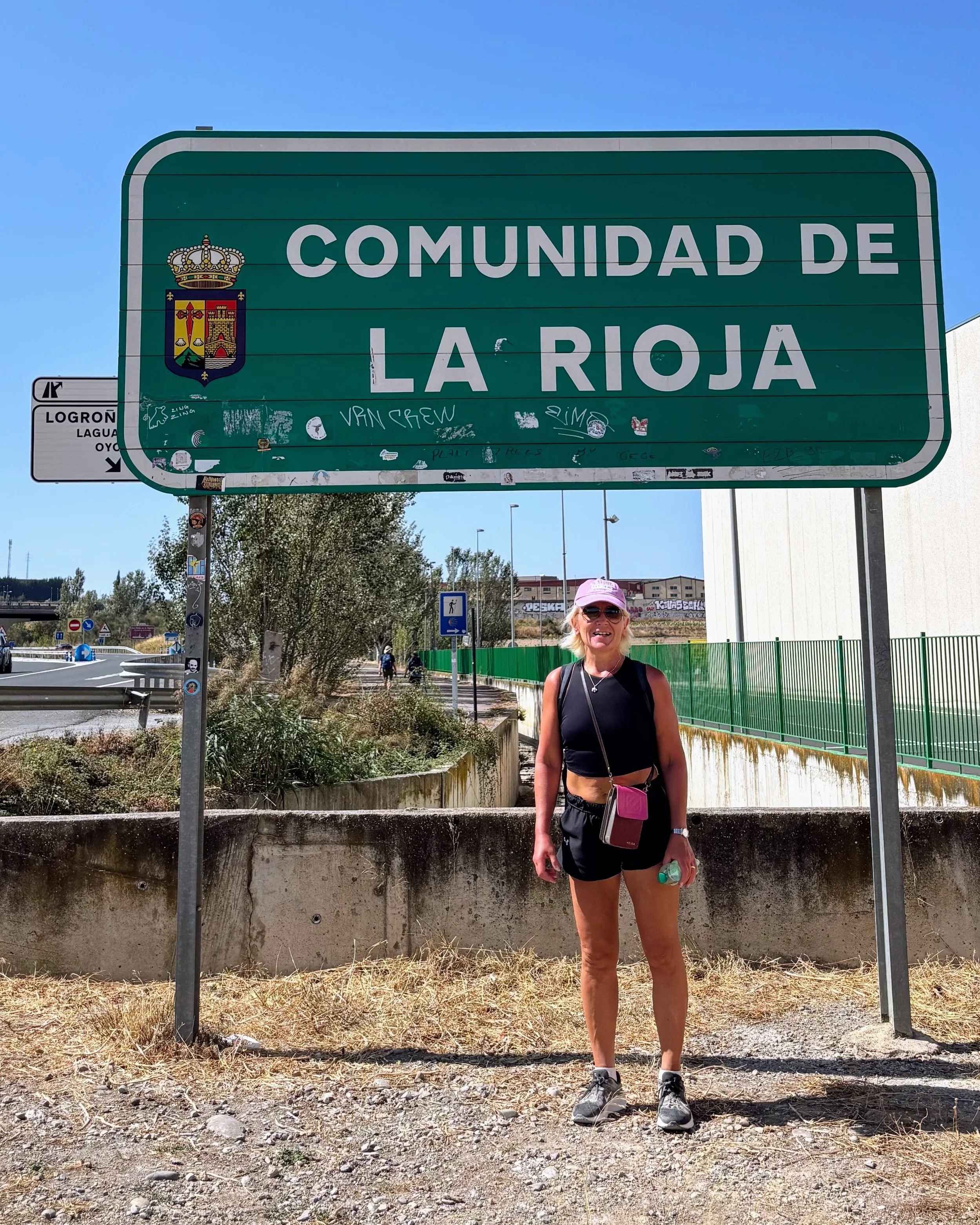 Anita standing in front of the sign that says Comunidad La Rioja in Spain