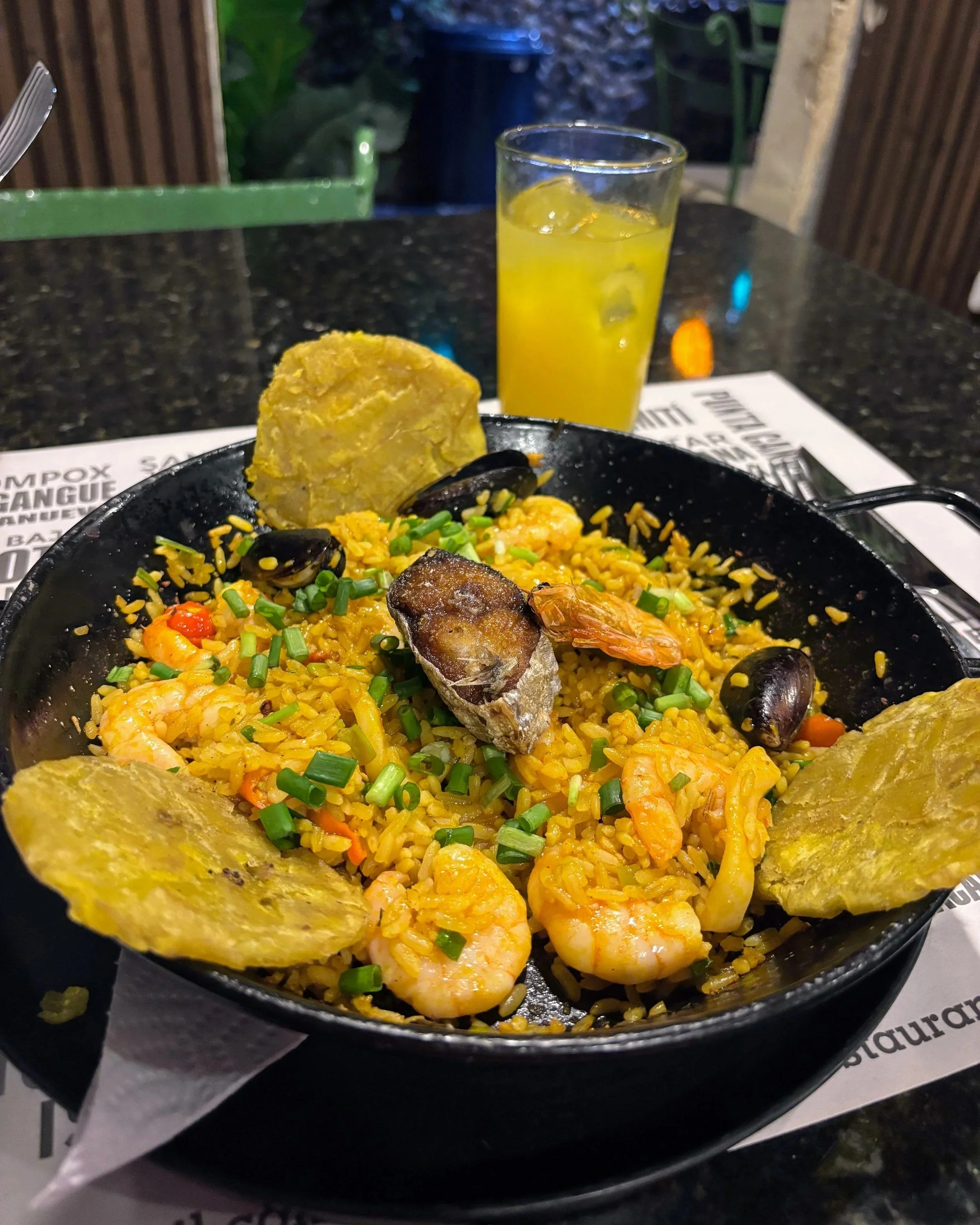 Seafood rice with patacones at La Mulata, Cartagena, with a glass of maracuya juice in the background