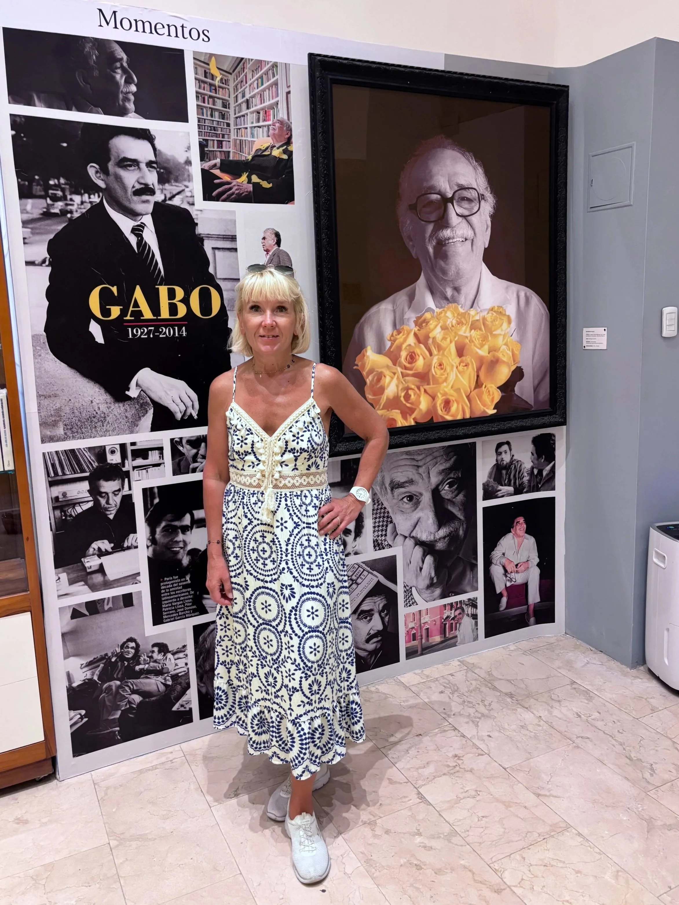Anita in front of photos of Gabriel Garcia Marquez