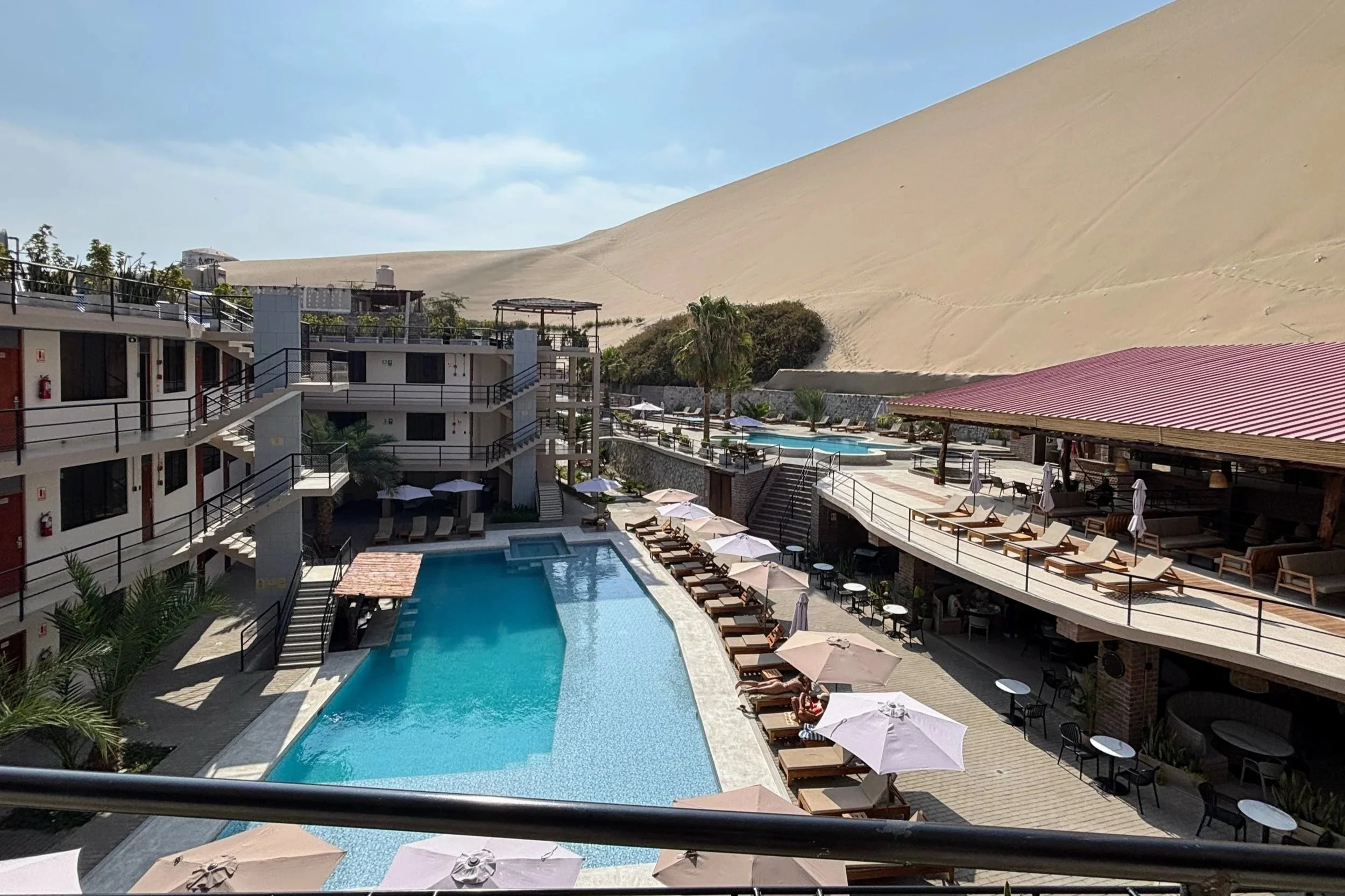 view of the inside courtyard of the Senoma oasis hotel in Huacachina Peru. There's a swimming pool in the center.