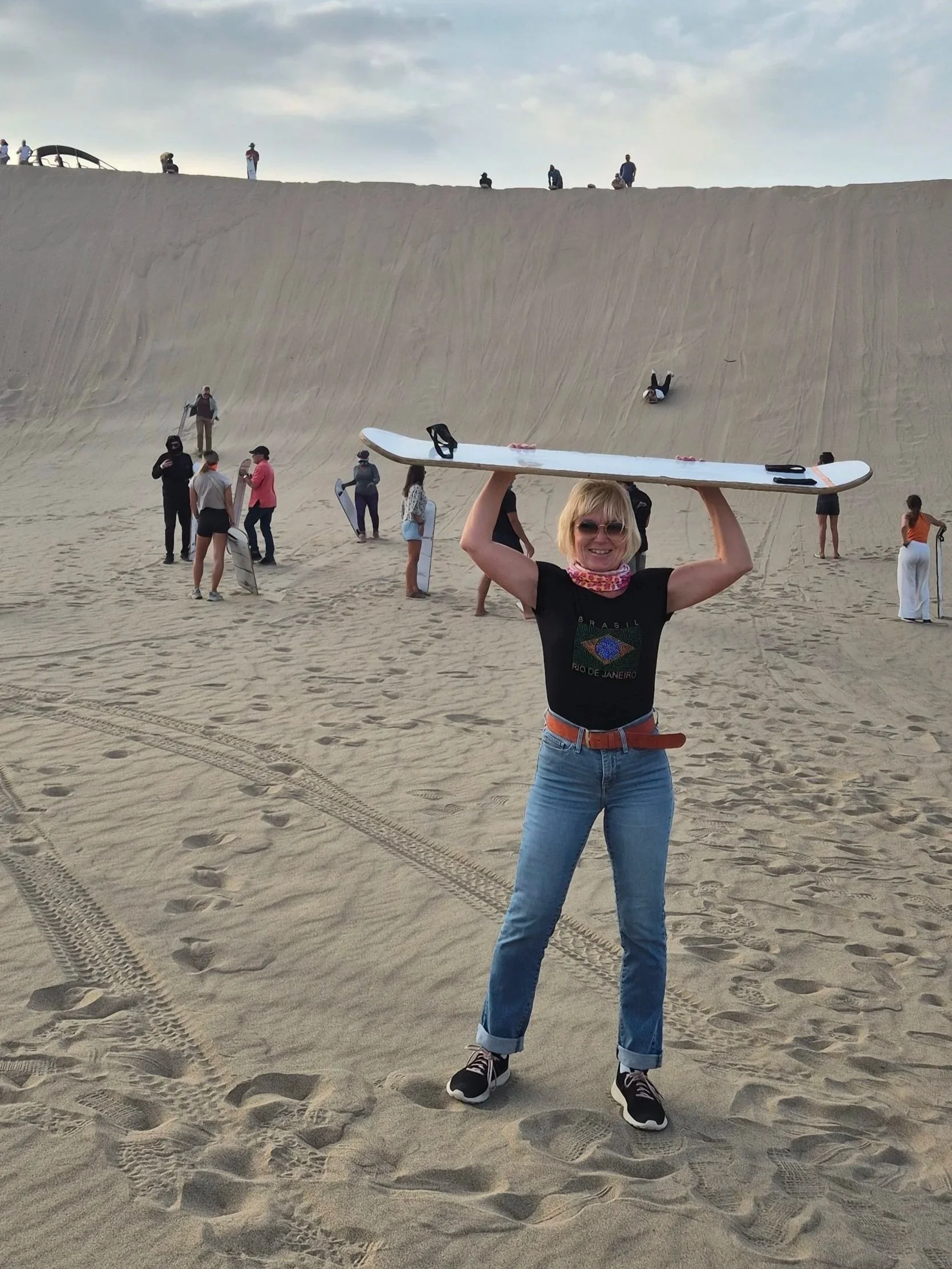 Anita with sandboard in Ica desert Huacachina Peru