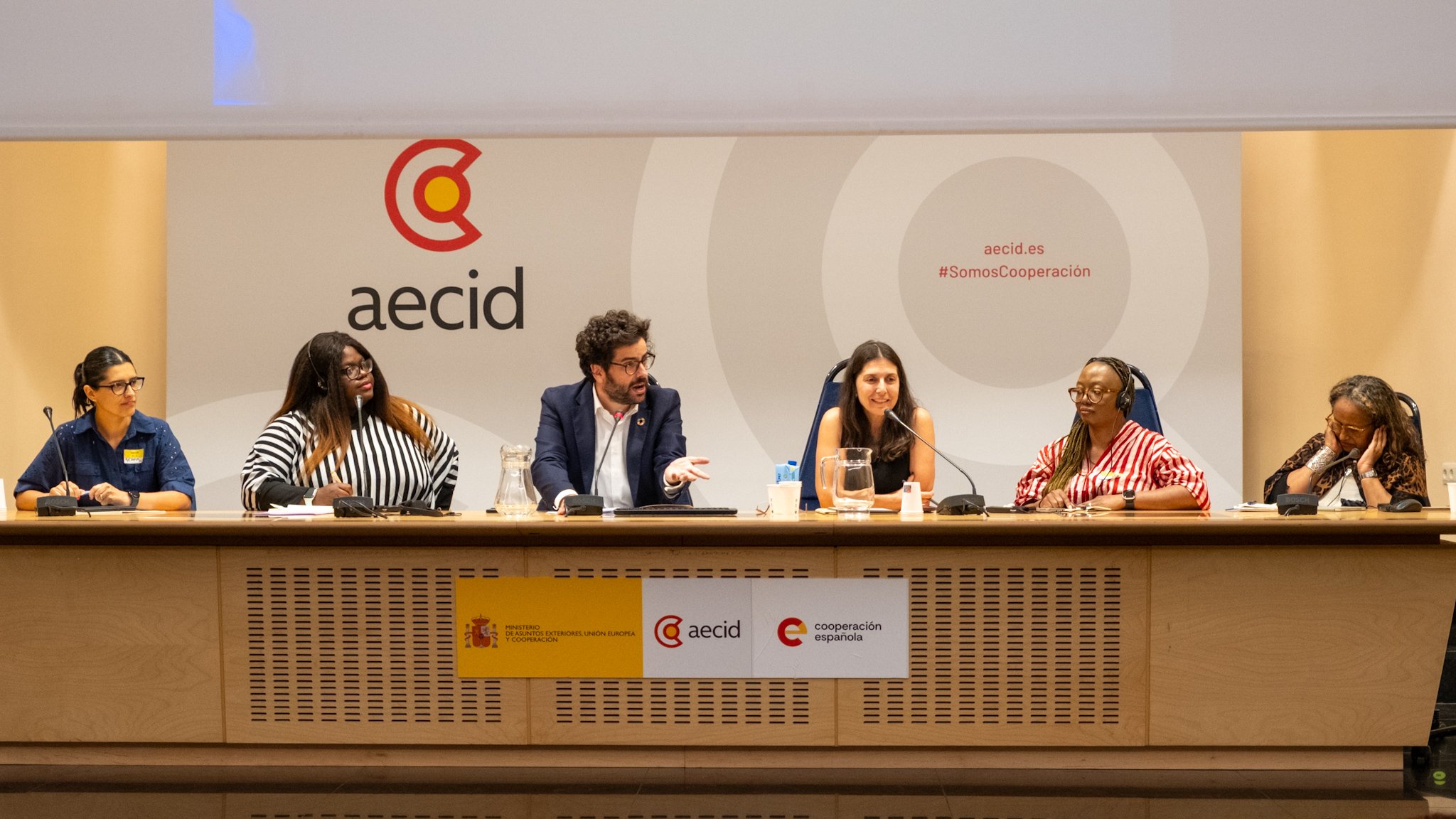 A panel of six speakers on a panel at the AECID Spanish development agency