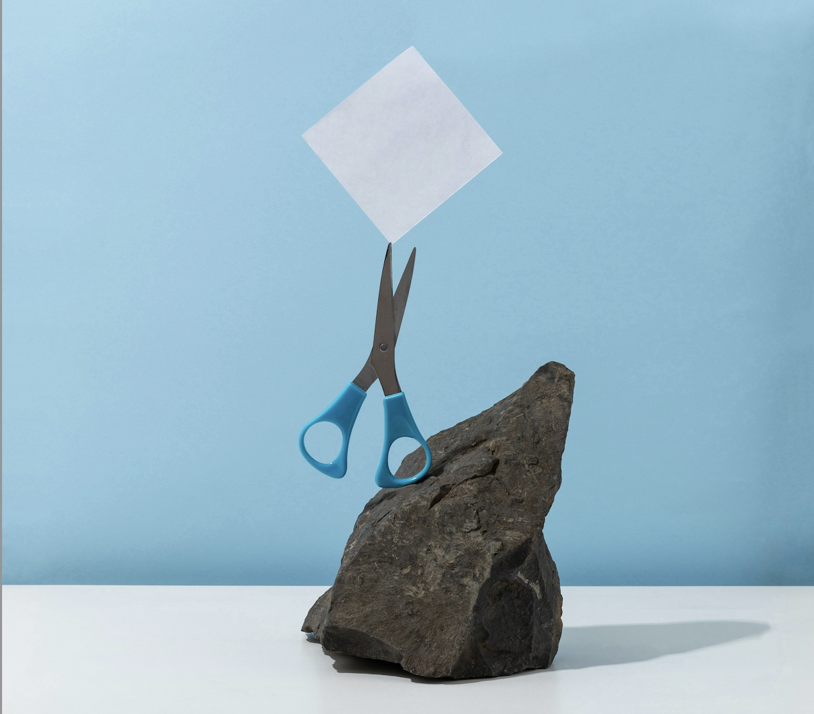 a rock, pair of scissors, and paper stacked on top of each other over a blue background - play rock, paper, scissors with your teen
