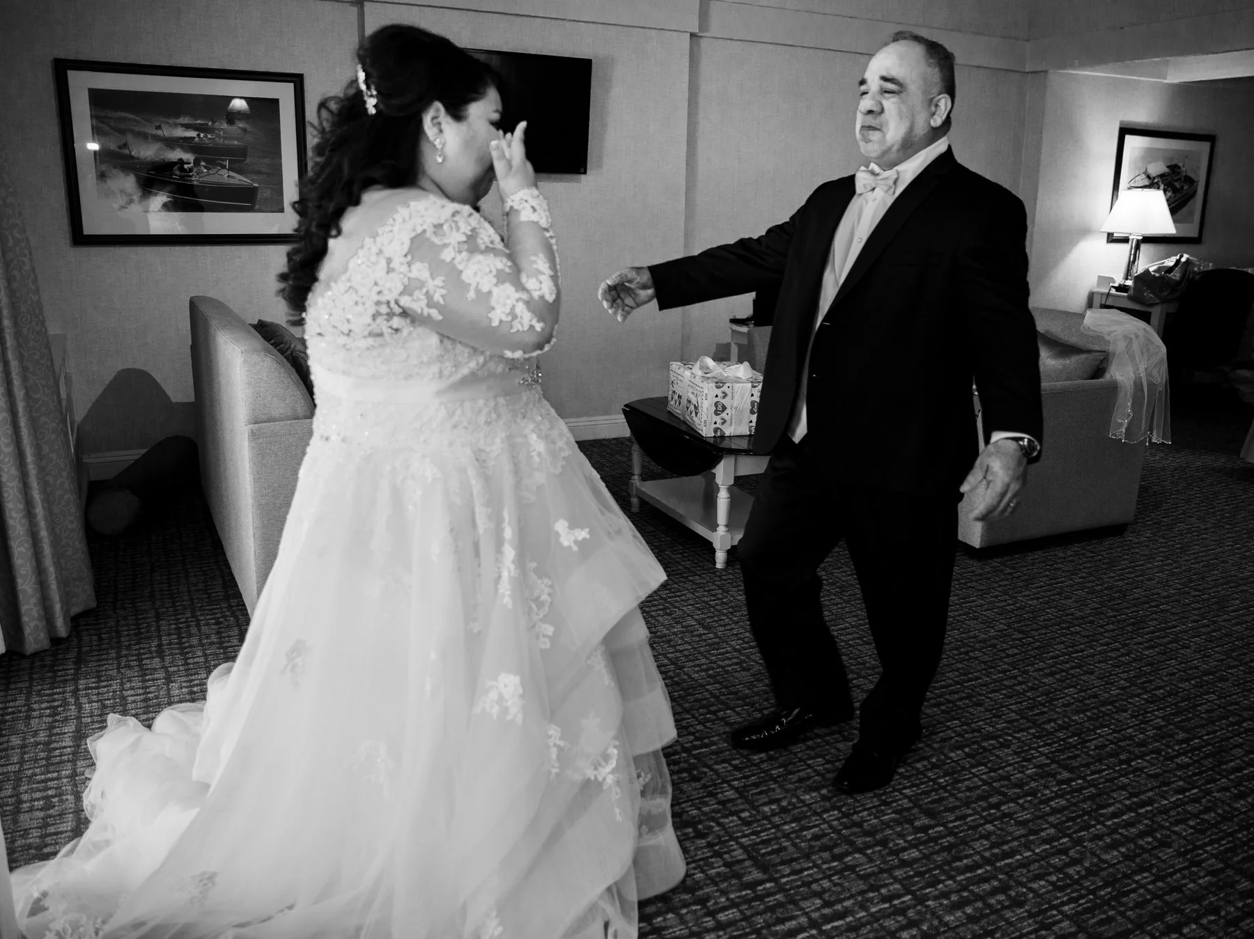 Father of the bride gets ready to hug her as she wipes tears from her eyes. This is a first look between the father and the bride.