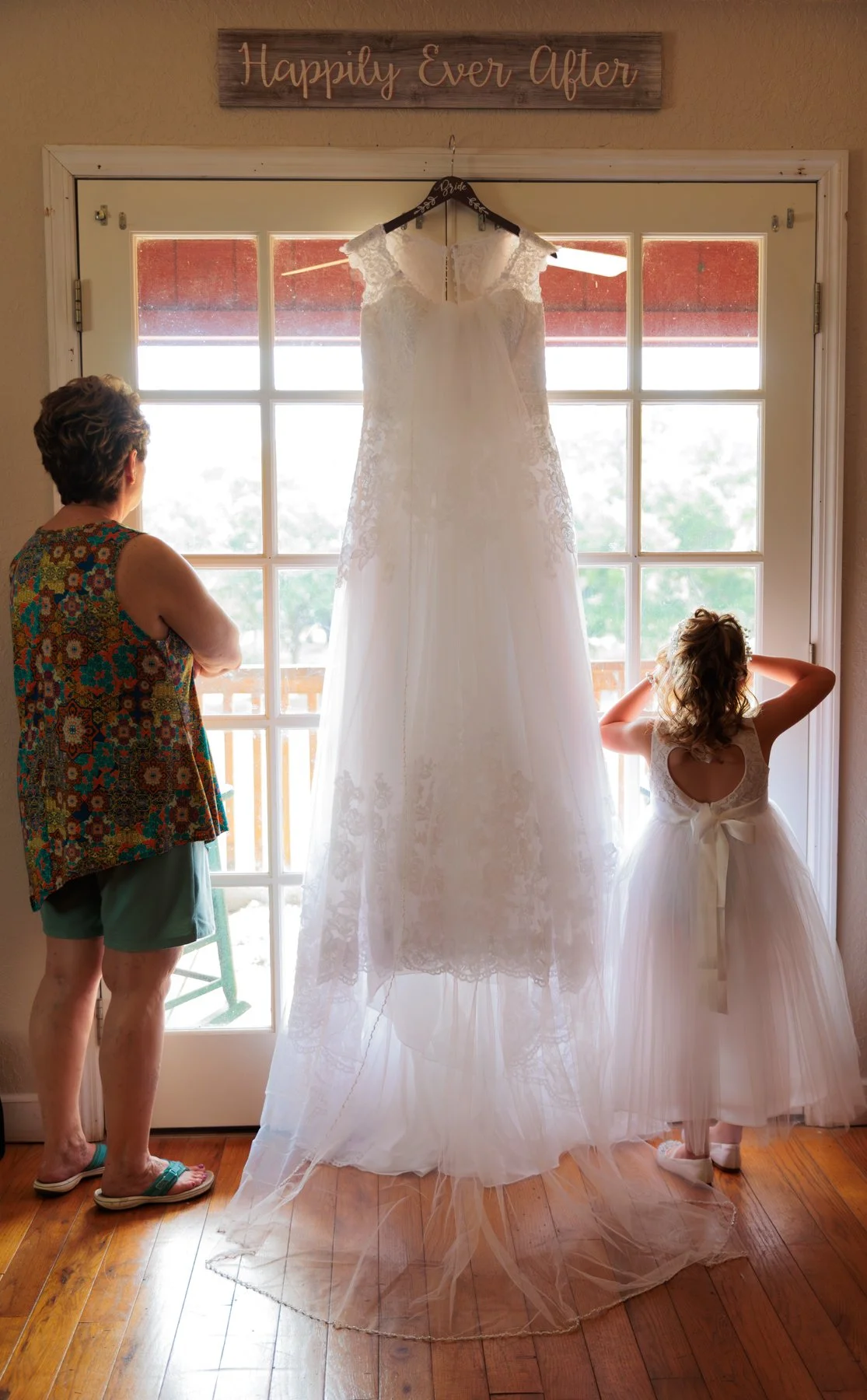 The flower girl looks out the window while waiting for the start of the wedding ceremony.