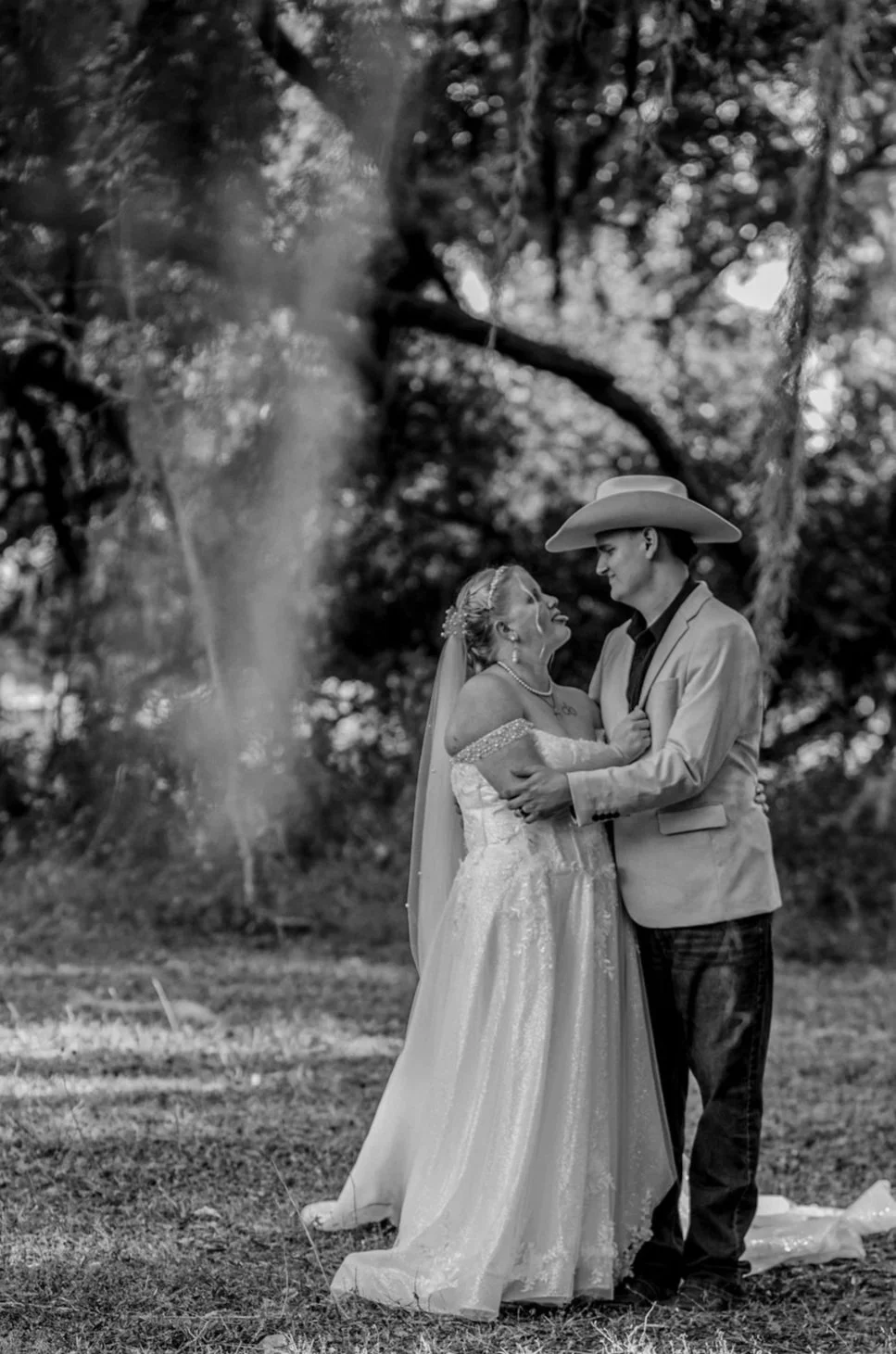 The bride sticks her tongue out at the groom during a posed portrait.