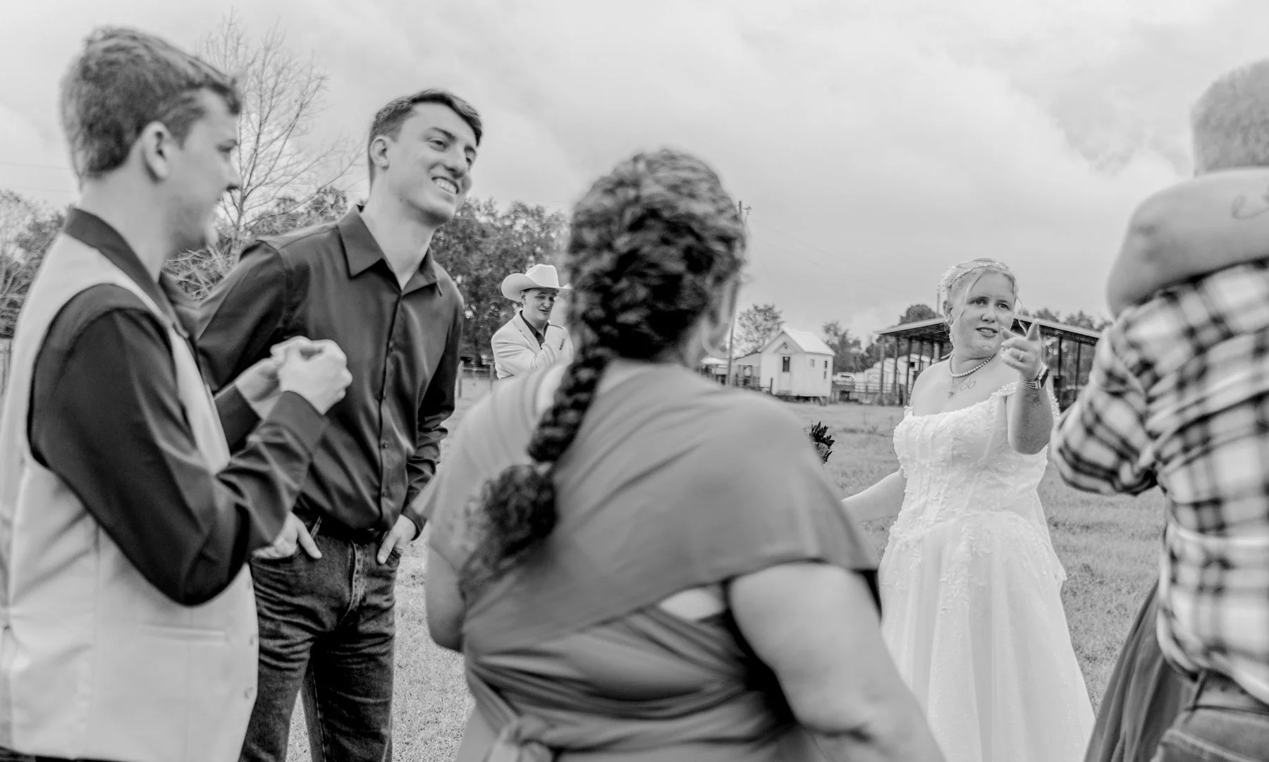 Maddie the bride points a finger at one of her family members crying while her groom Justyn wipes tears from his eyes in the background.