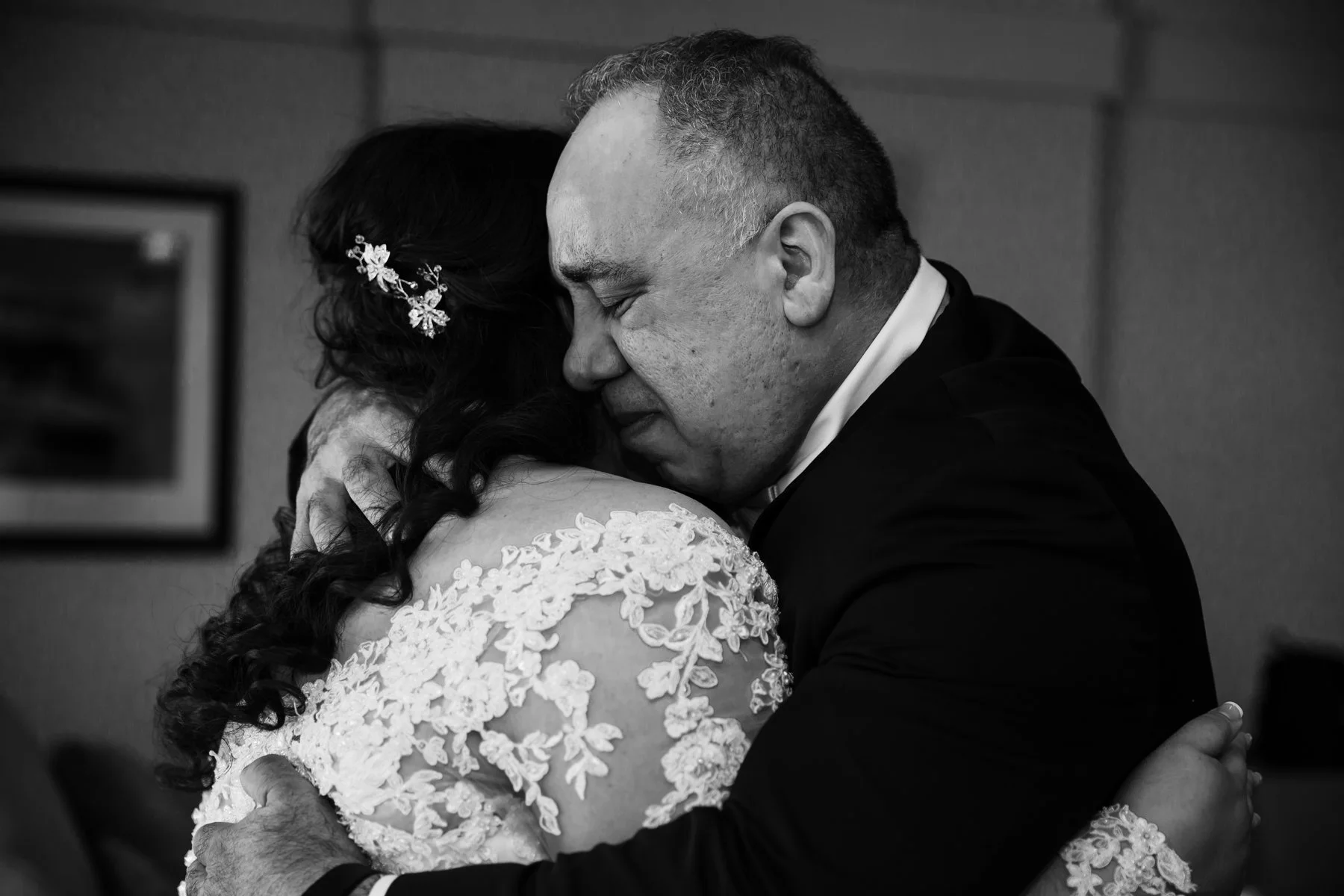 Father of the bride is hugging his daughter. Both are crying.