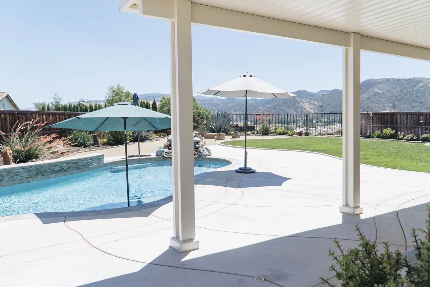 White patio cover with matching color AlumaBase post base covers installed