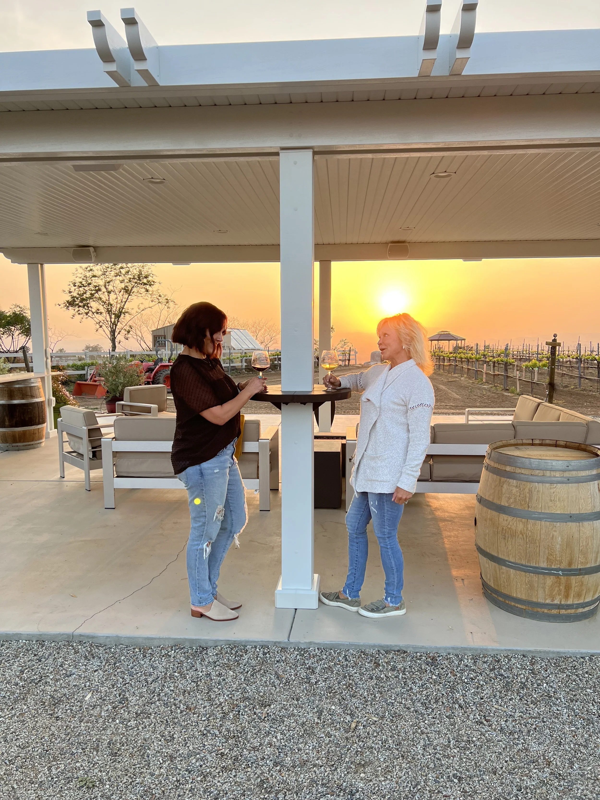 Two joyful women enjoying drinks on their AlumaTable