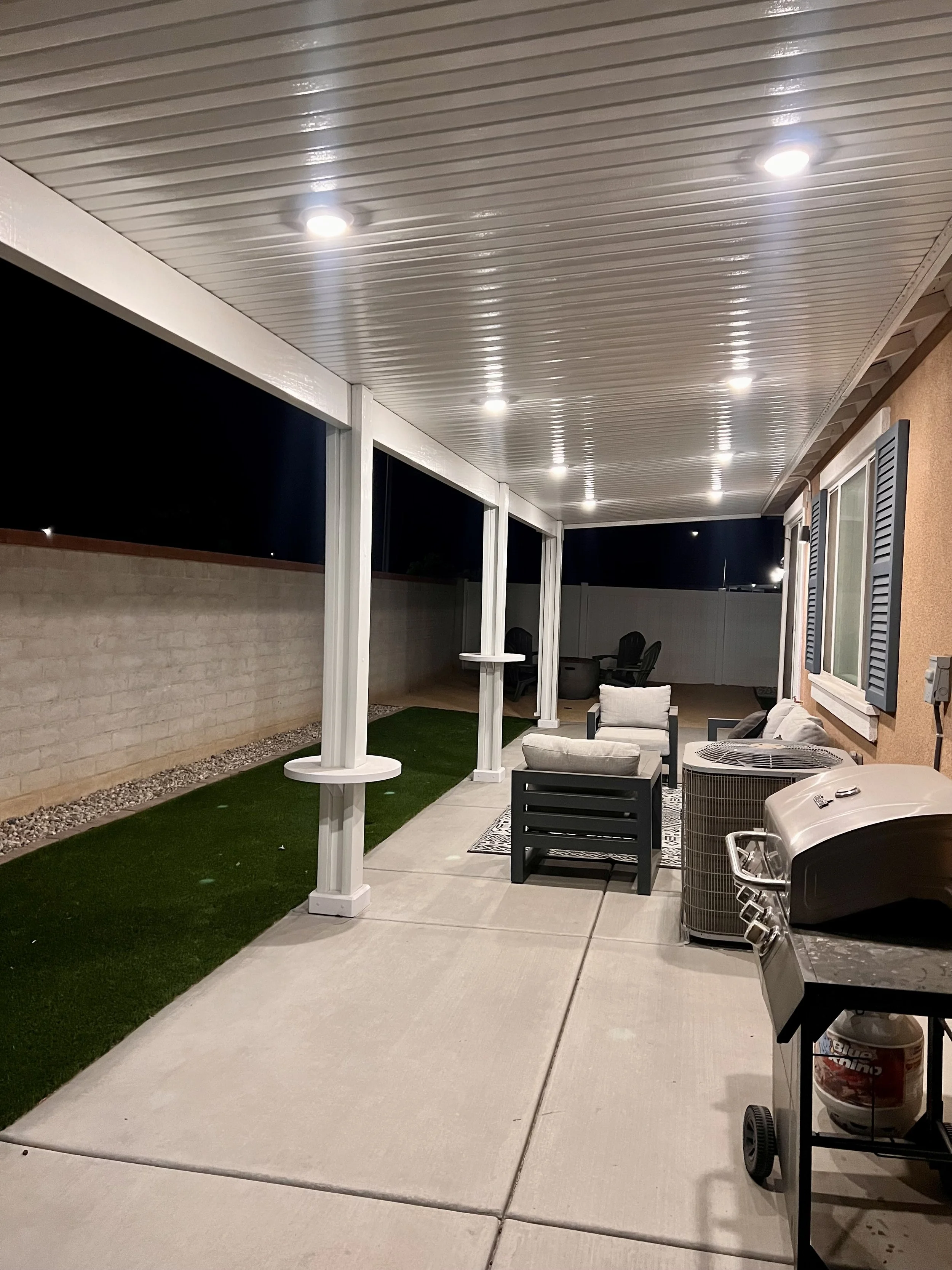 White patio cover with lighting installed and AlumaTables on each post