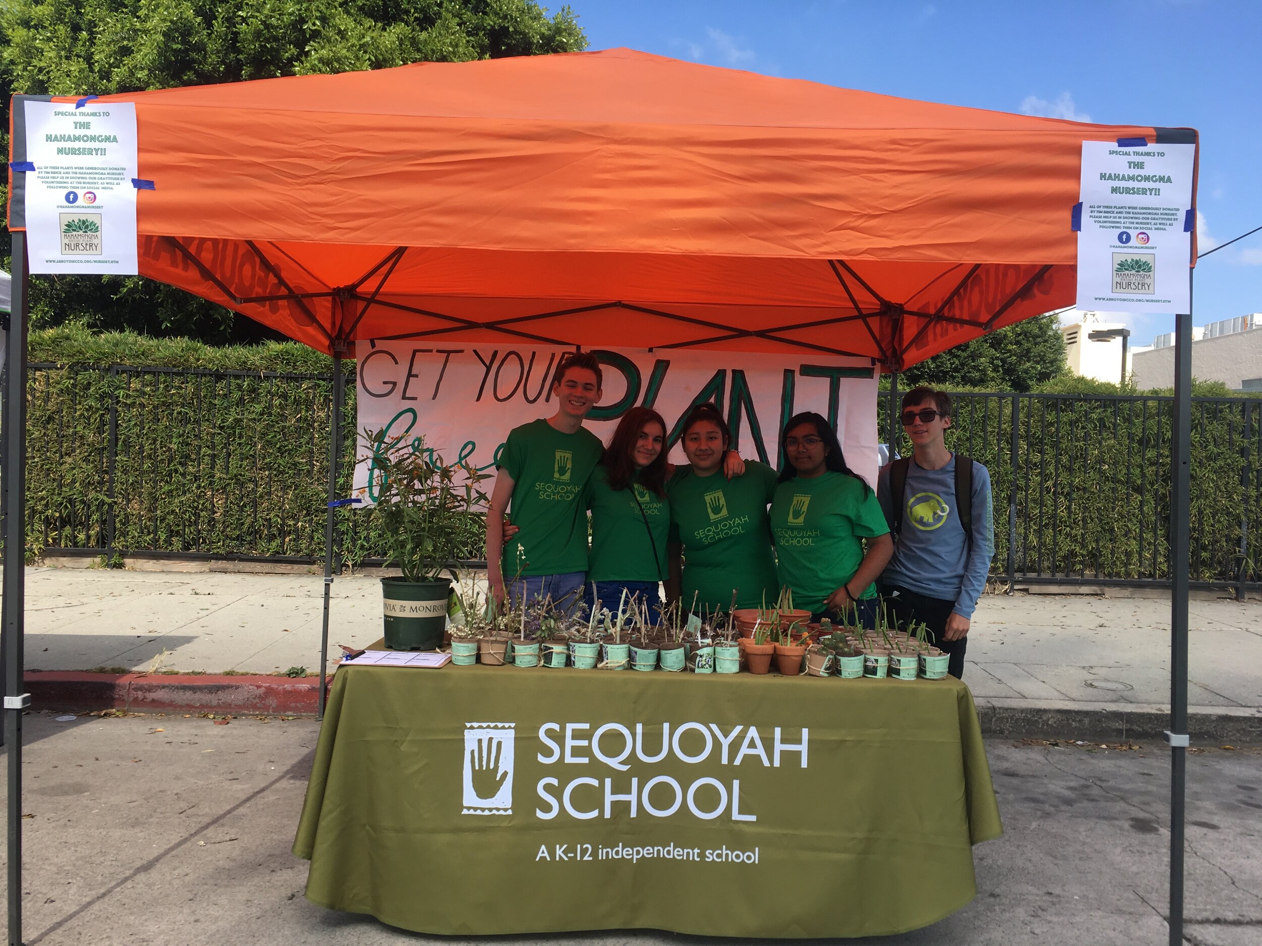 Students handing out native plants at the North Hollywood Farmers' Market to promote mental wellbeing.