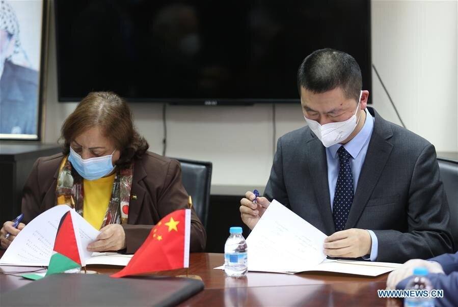 Director of the Office of the People's Republic of China to the State of Palestine Guo Wei and Palestinian Health Minister Mai al-Kaila sign documents during a handover ceremony of medical supplies provided by China in the West Bank city of Ramallah…