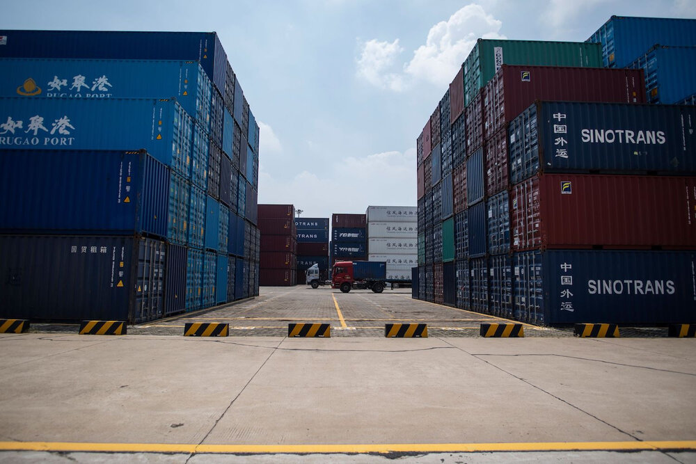 A truck transports a shipping container at a port in Zhangjiagang, China, on Aug. 7. [Johannes Eisele/AFP/Getty Images]