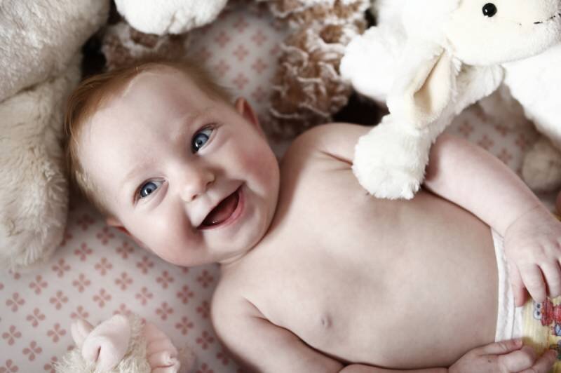 bliss photographic calgary newborn photography smiling baby in crib.jpg