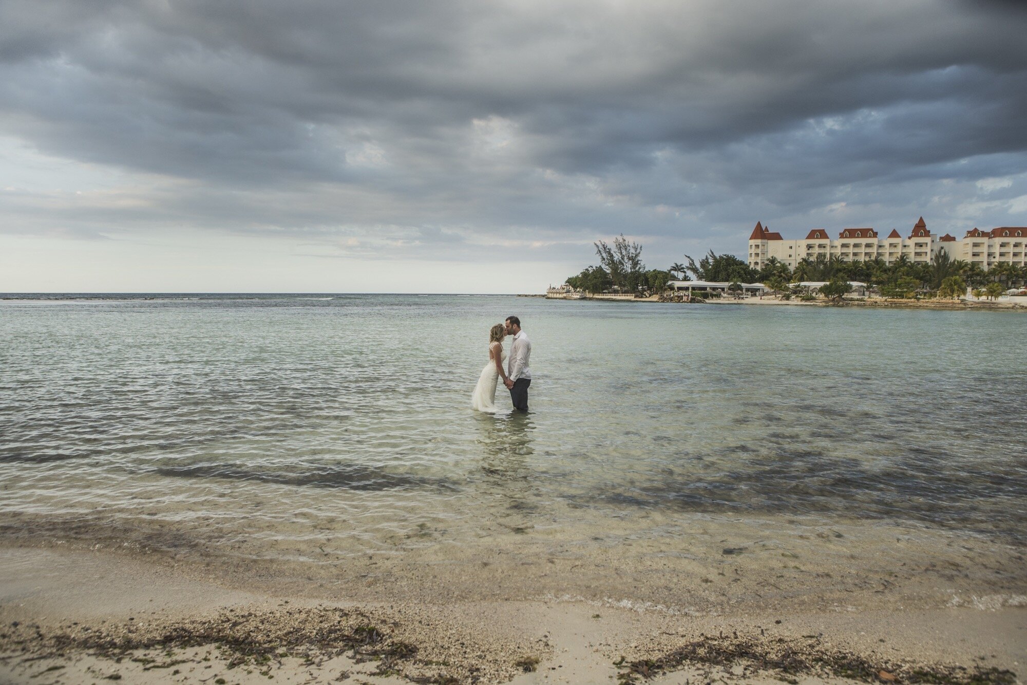bride groom standing in ocean resort in background.jpg