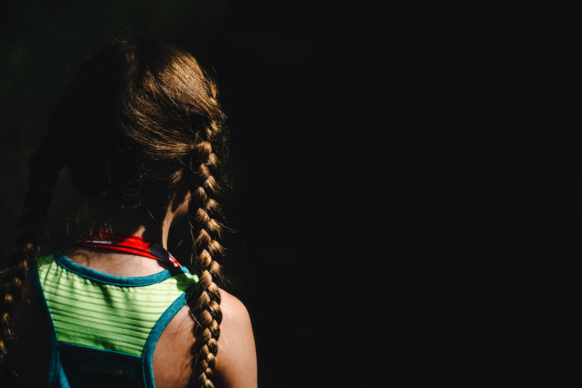 little-girl-braids-direct-light-dark-background-lyra-lee-documentary-photographer-family-bismarck-north-dakota-click-pro-6092.jpg