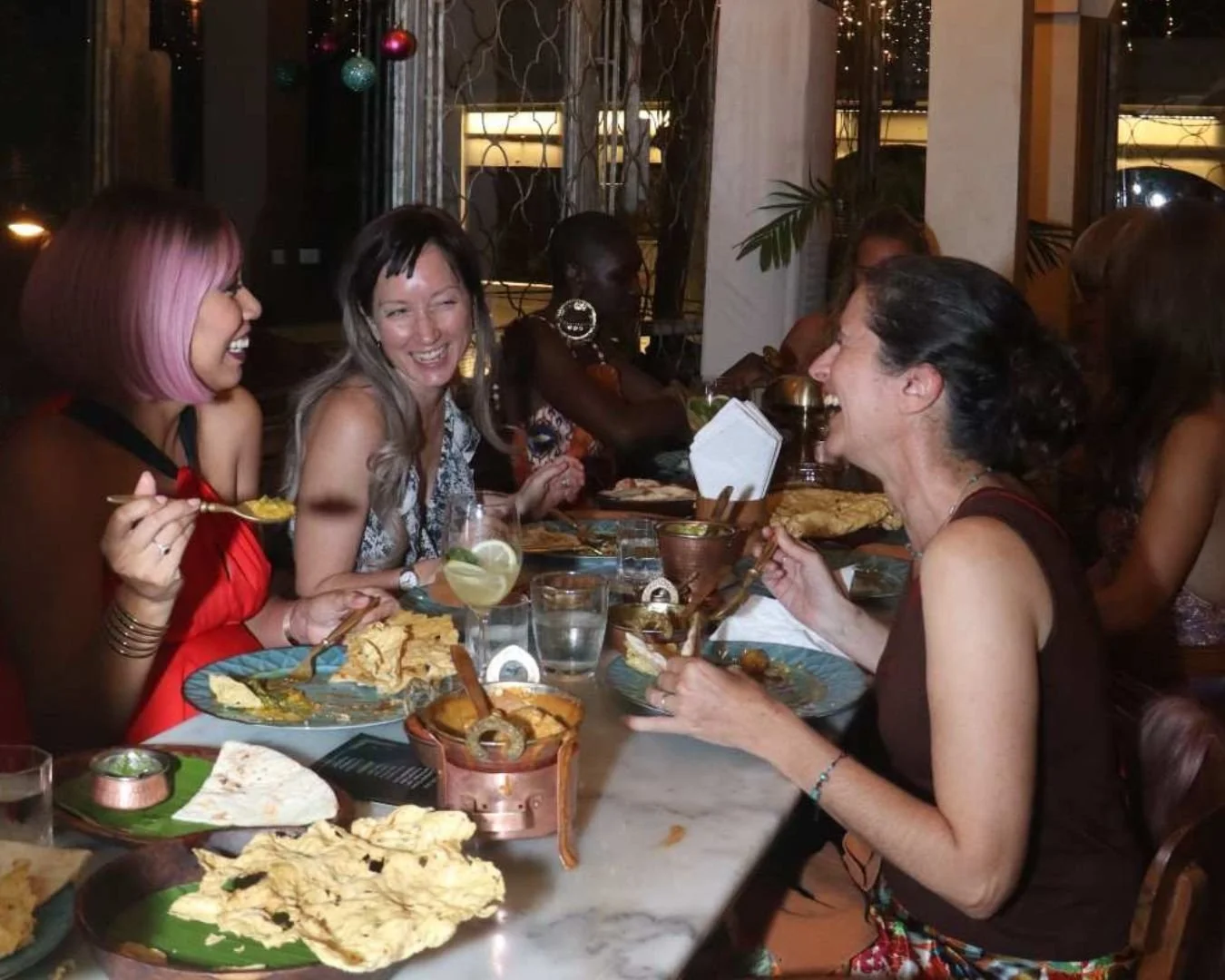 Friends sharing handcrafted cocktails while enjoying conversation at Pesona Lounge in Ubud.
