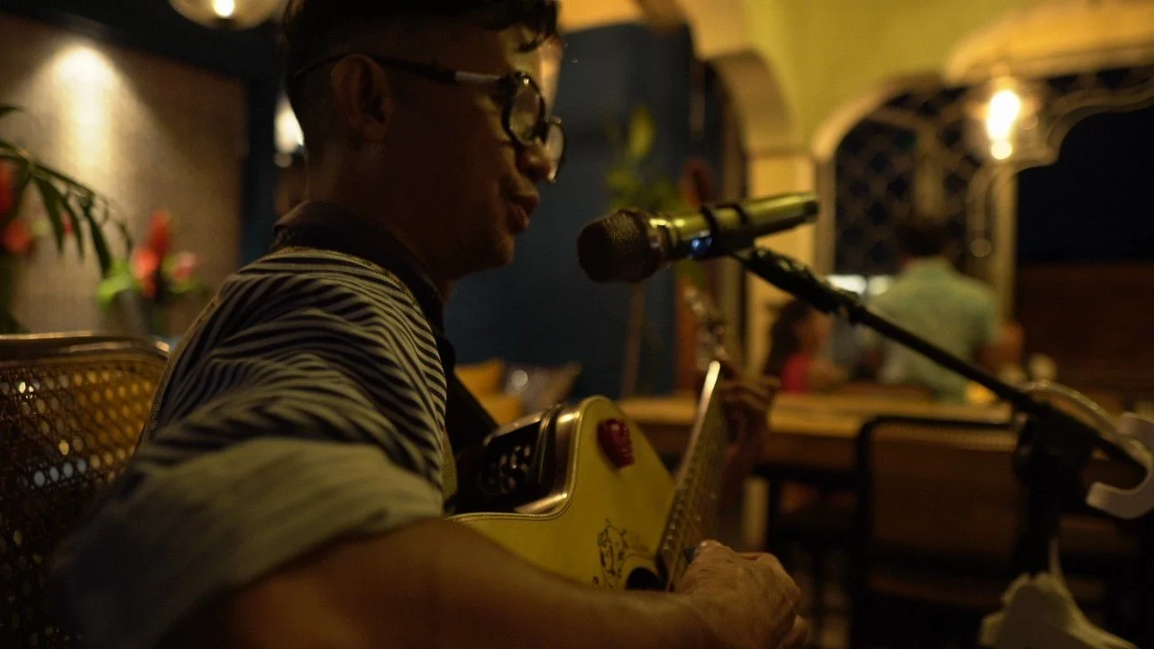 A live musician performing during dinner at Pesona Lounge in Ubud, creating a warm and relaxing dining atmosphere.